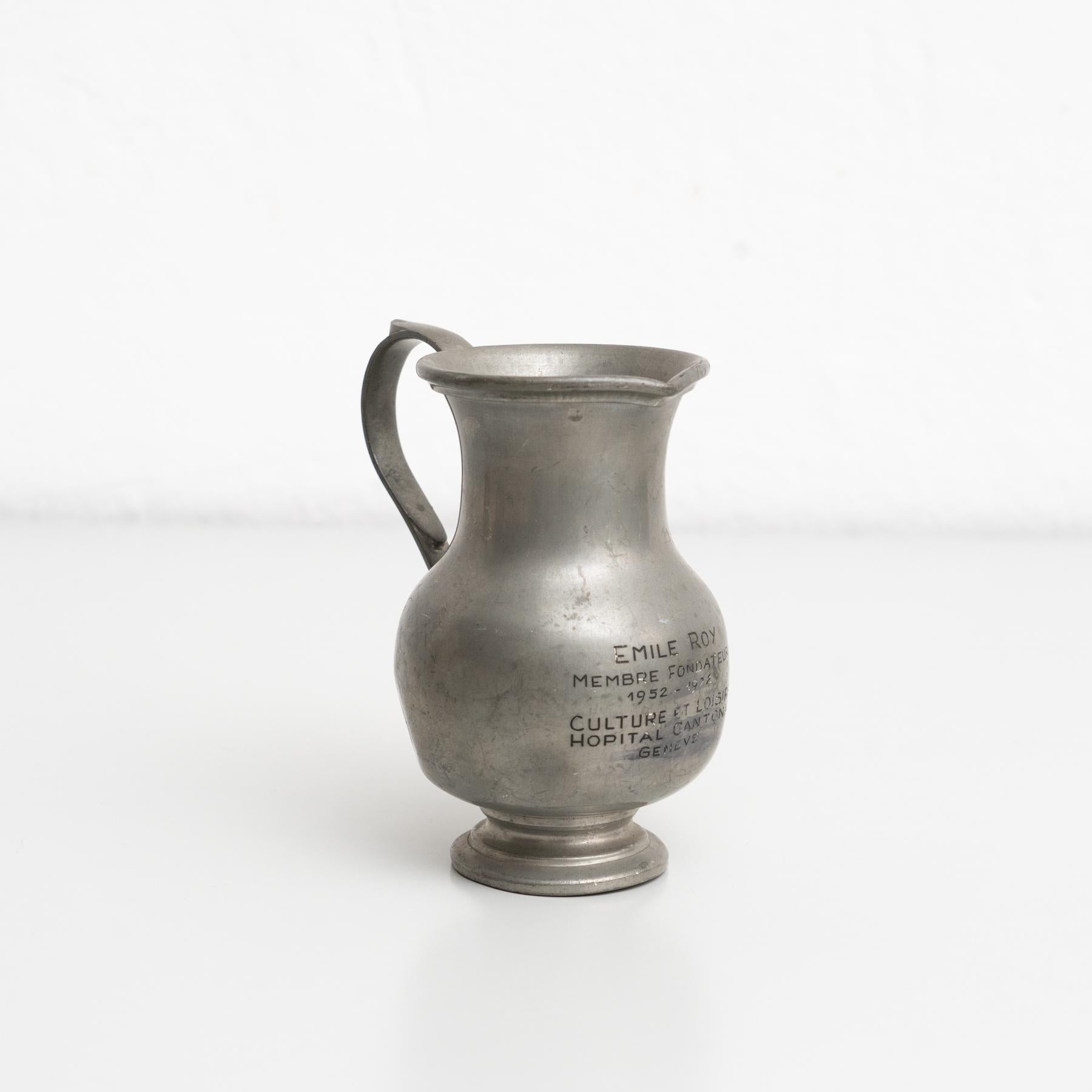 Vintage metal commemorative metal jug.

By unknown manufacturer, made in Switzerland circa 1970.

In original condition, with minor wear consistent with age and use, preserving a beautiful patina.

Materials:
Metal.
 