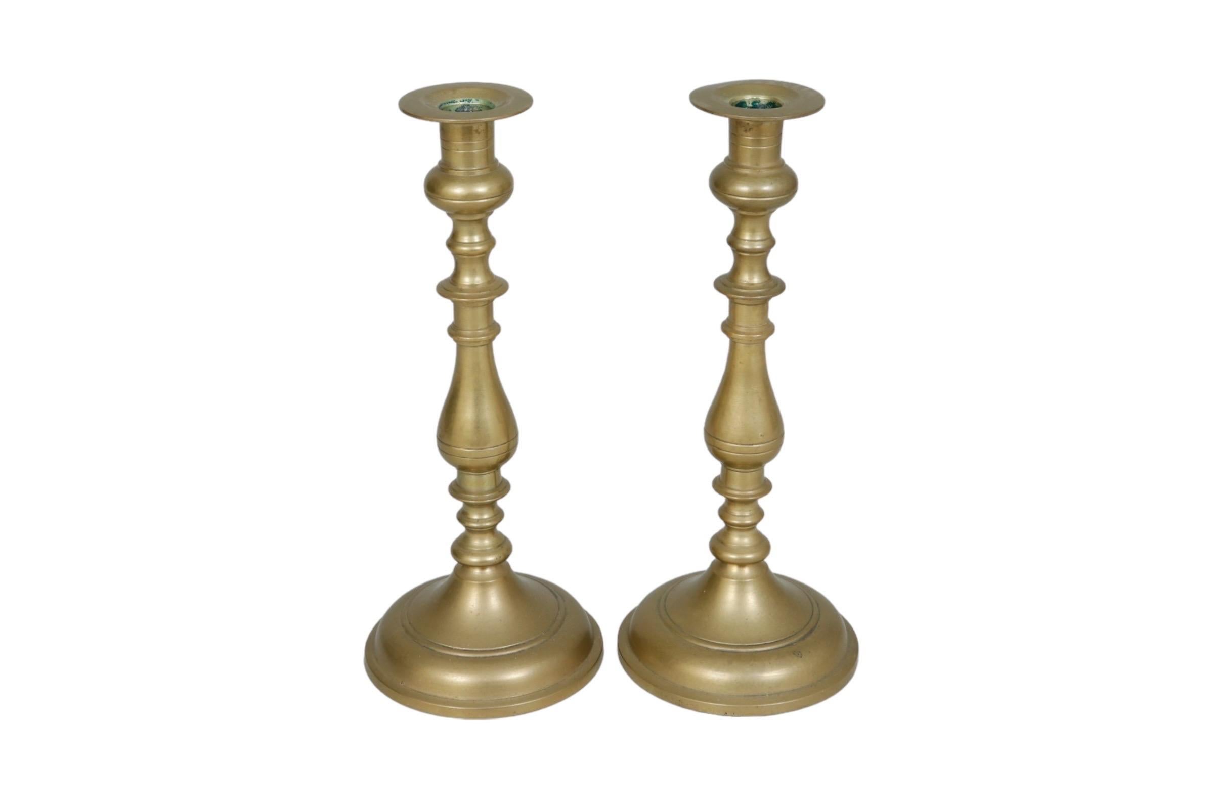 Una coppia di portacandele tradizionali torniti in ottone. Le colonne a balaustro tornite sono decorate con dettagli di linea. Dimensioni per portacandele.