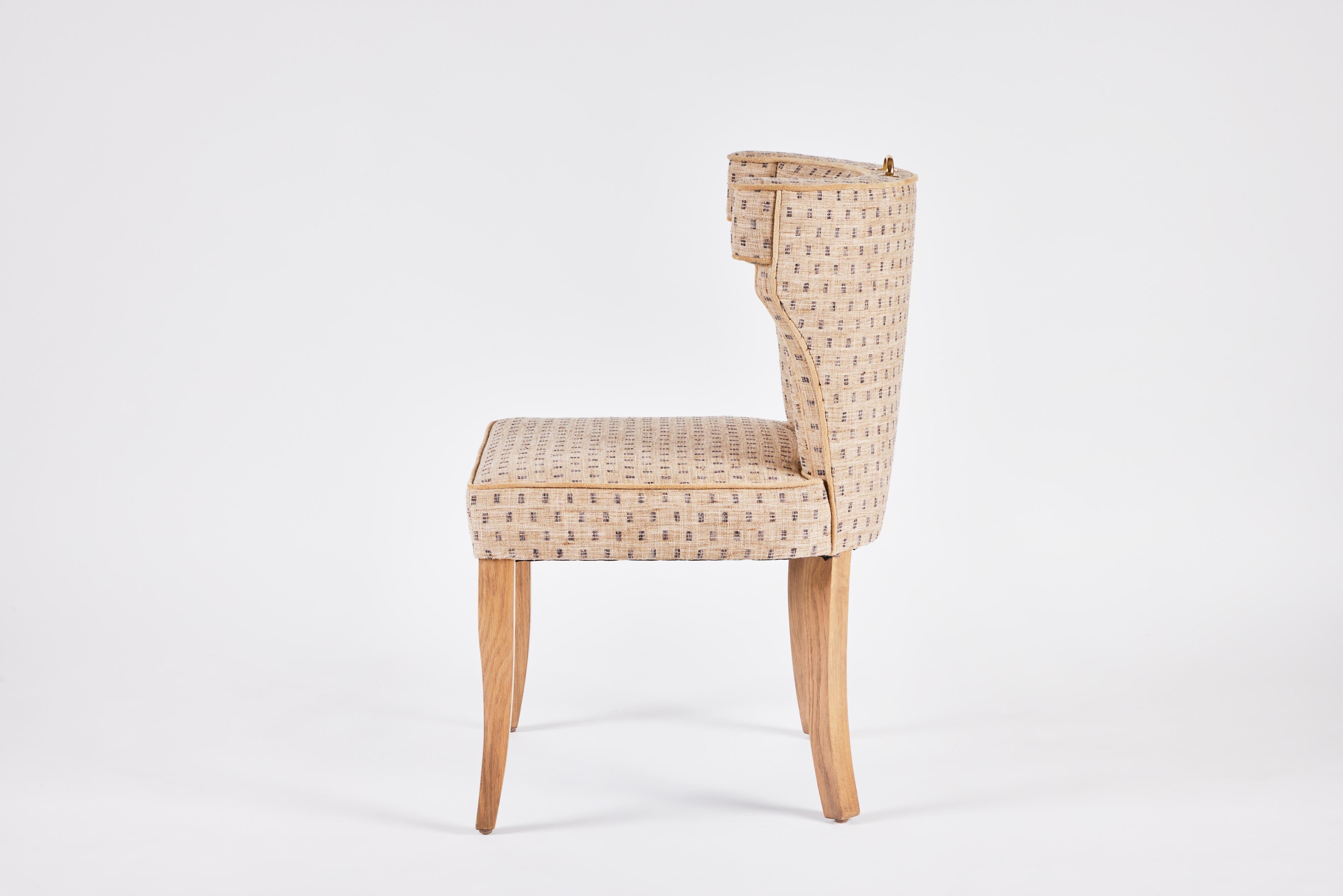 The Martin and Brockett Hale chair has a fully upholstered curved back, without nailhead trim. Oak saber legs with an unlacquered brass handle detail. 

C.O.M. only -3 yards 
Other wood finishes available.

Lead time: 8-10 weeks.