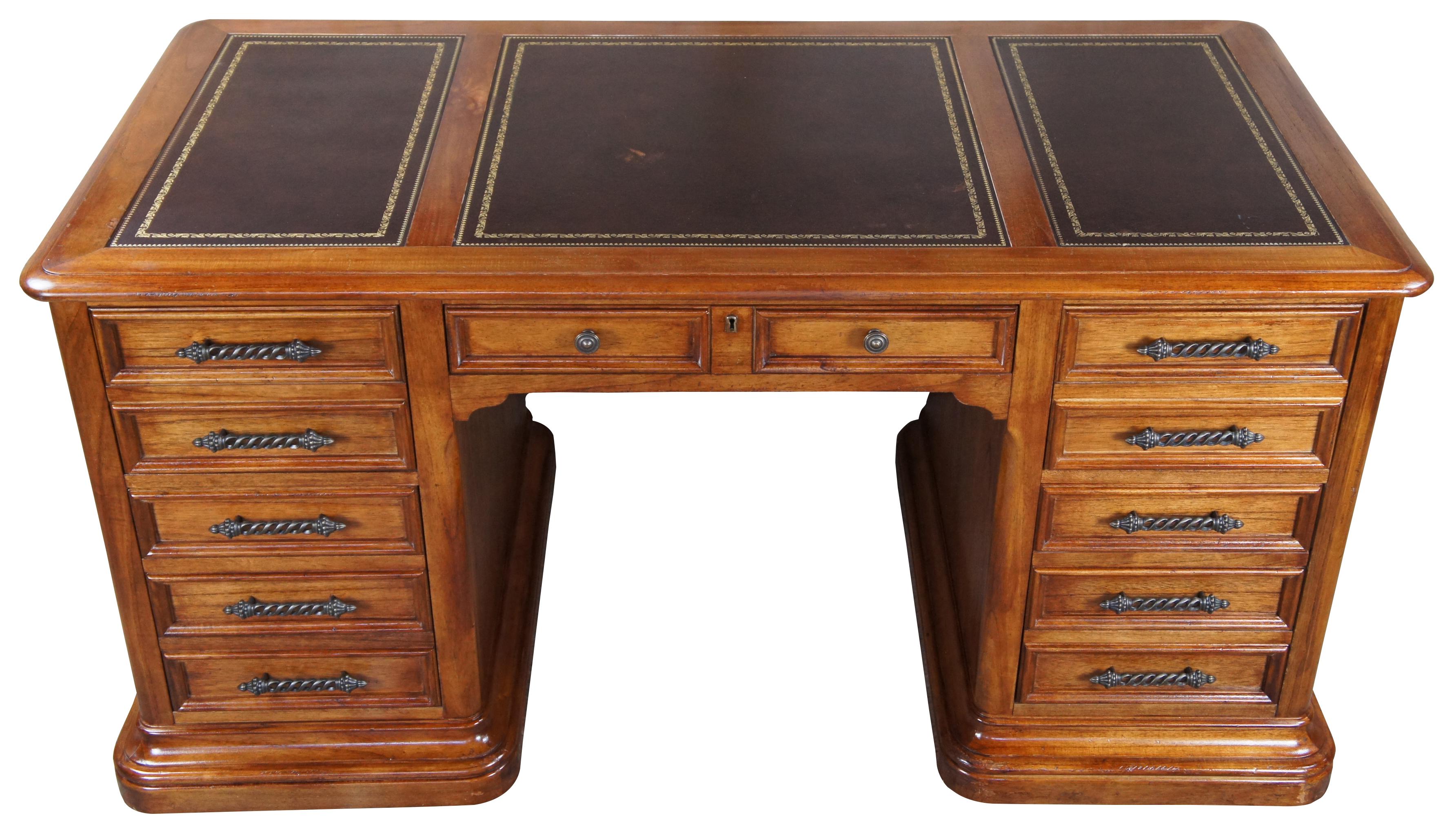 Hekman oak executive office desk. Features a brown and gold tooled leather top 5 drawers and barley twisted hardware. Includes large deepwell drawers with file storage below and a central lockable keyboard drawer. Size: 60