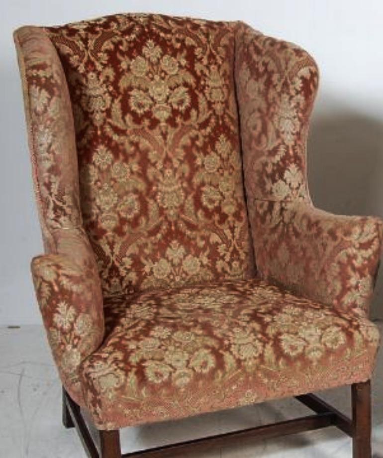 A comfortable traditional wingback armchair. A high shaped back, deep seat, sinuously curved wings, out-swept arms and H-stretcher base on straight legs.