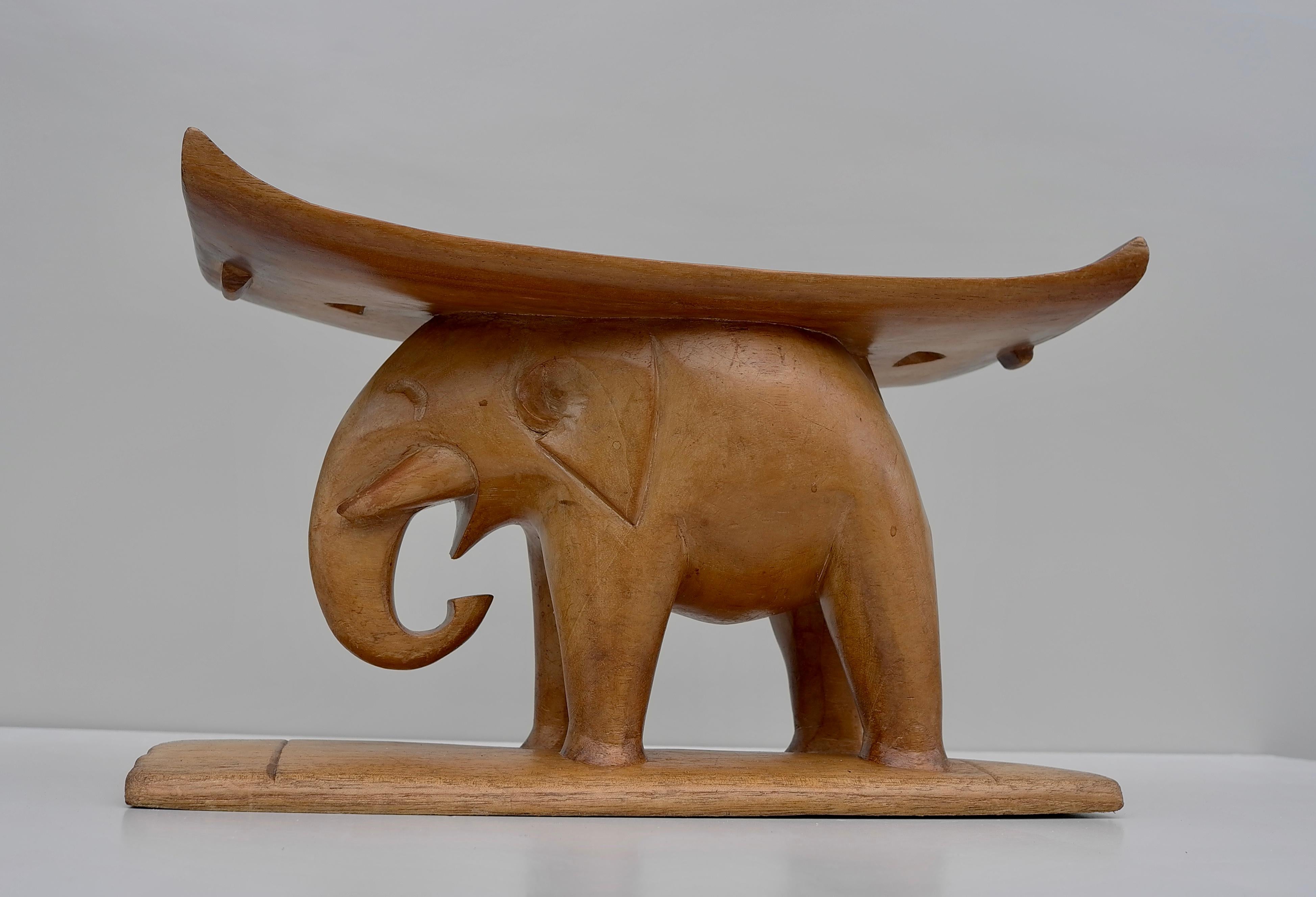 Authentic African carved wooden elephant stool. Originates from the Ashanti Tribe of Ghana. It is of traditional form with the elephant stood on a flat base with a curved seat on his back. It is excellent quality and the detail of carving around his