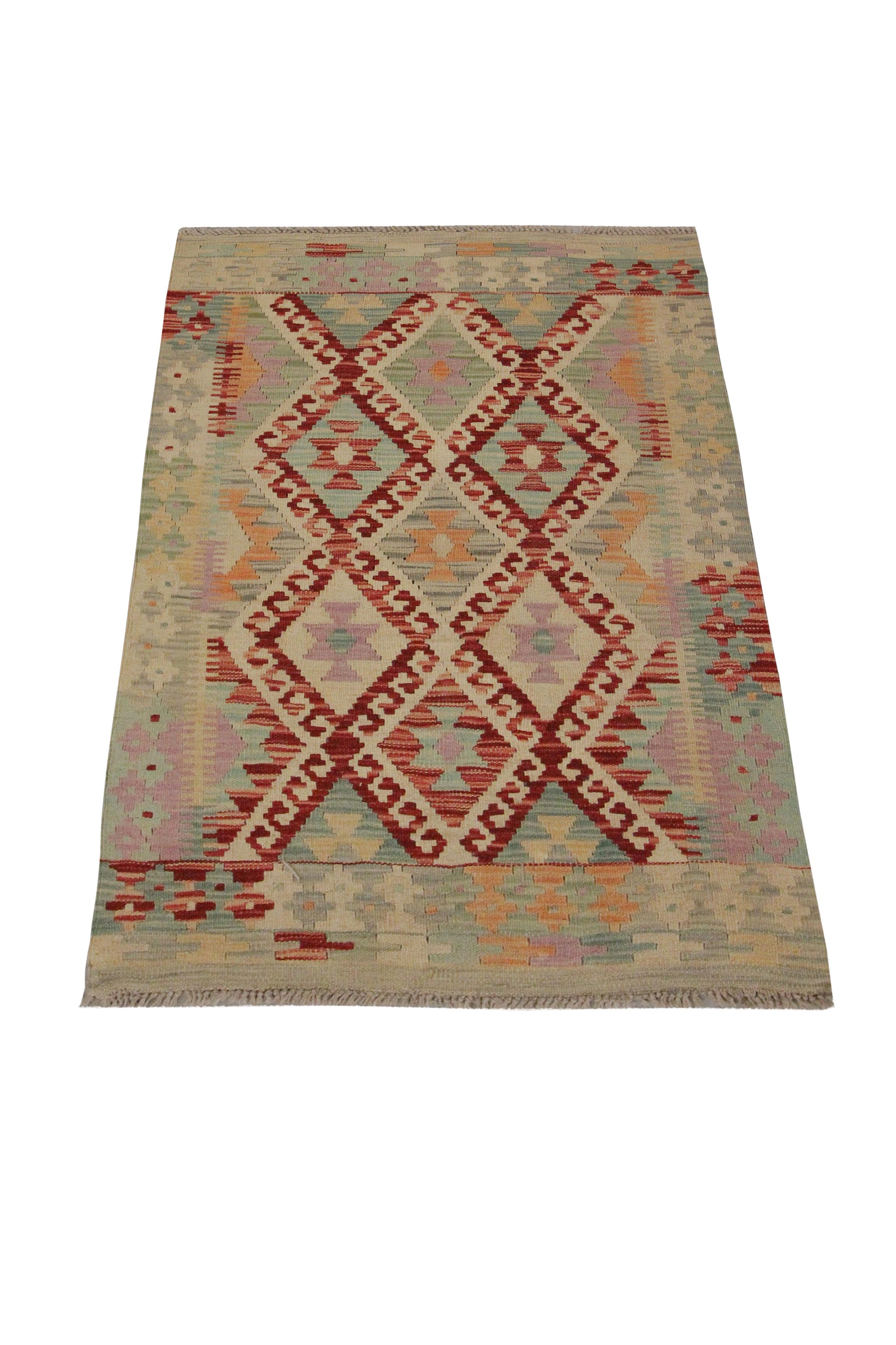 A sleek symmetrical design covers this beautiful wool Kilim woven with subtle accent colours of cream, red and green. The traditional tribal design displayed on this piece makes it the perfect accent piece for any small space. The colour and design