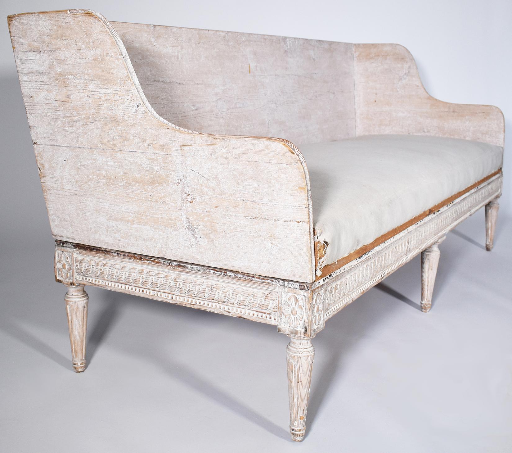 Stunning hand-carving on this 18th-century Trag sofa. It features elegant, hand-carved lines and a pale patina. It is a striking piece that has been reupholstered in an 18-ounce Belgian linen seat. An excellent find for an appreciative owner.