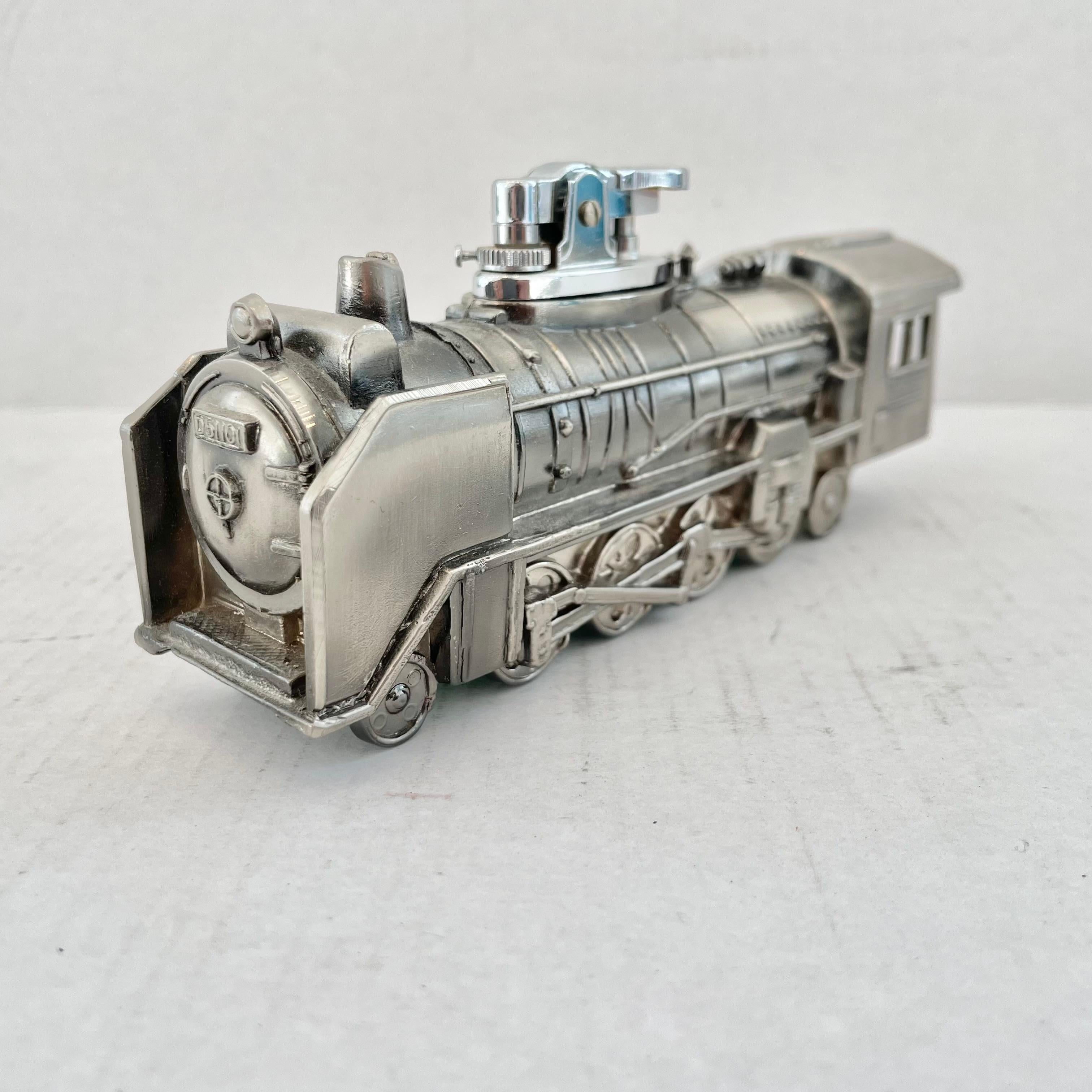 Cool vintage table lighter in the shape of a train engine. Made in Japan, 1980s. This piece has great balance and details. 'Japan' sticker on the green felt underside. Cool tobacco accessory and conversation piece. Working lighter. Good vintage