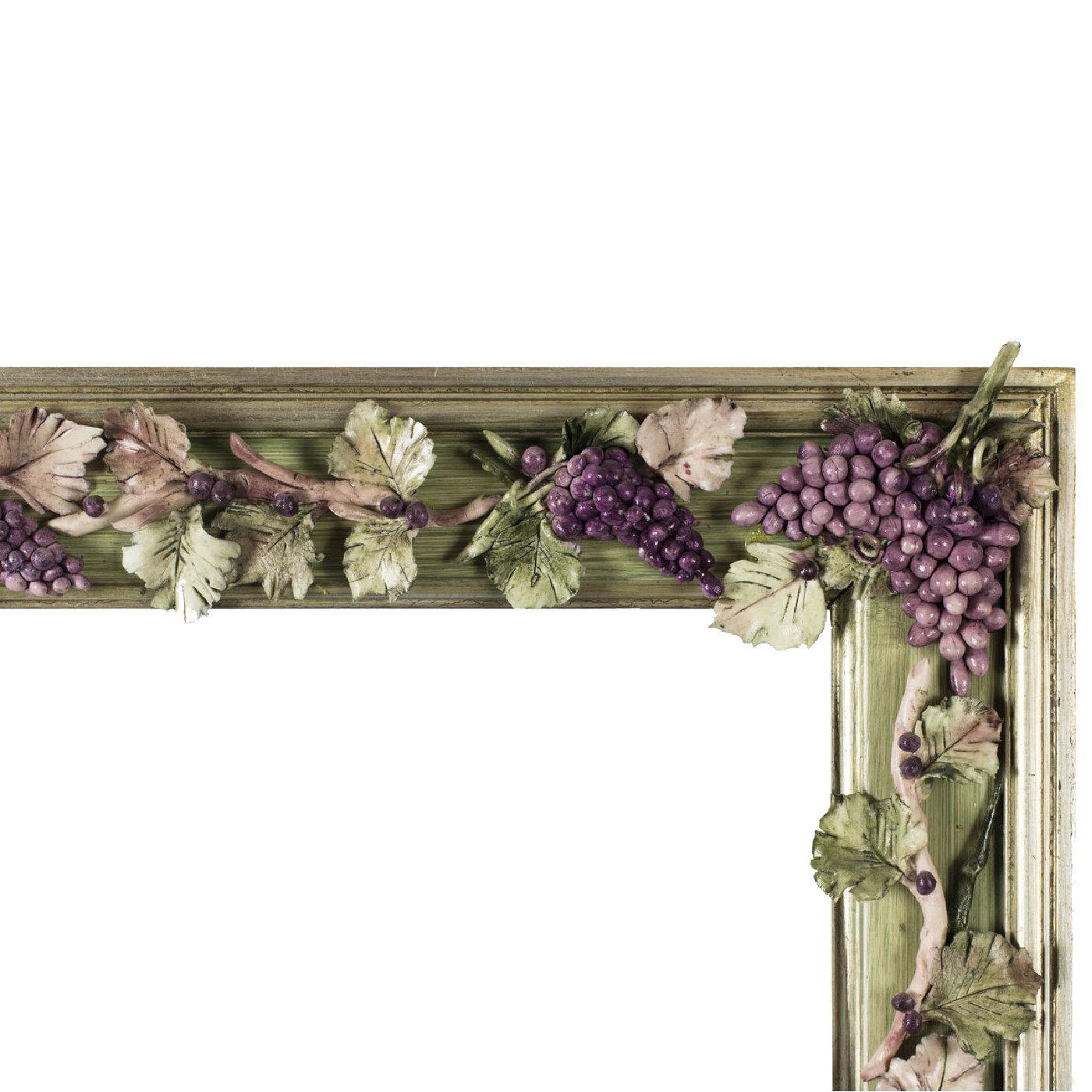 A veritable work of art by master carvers, framers, and ceramists, this charming frame boasts a singular character defined by a realistic grape detail around the frame. Best suited to a rustic-chic or modern interior, it is handcrafted of wood