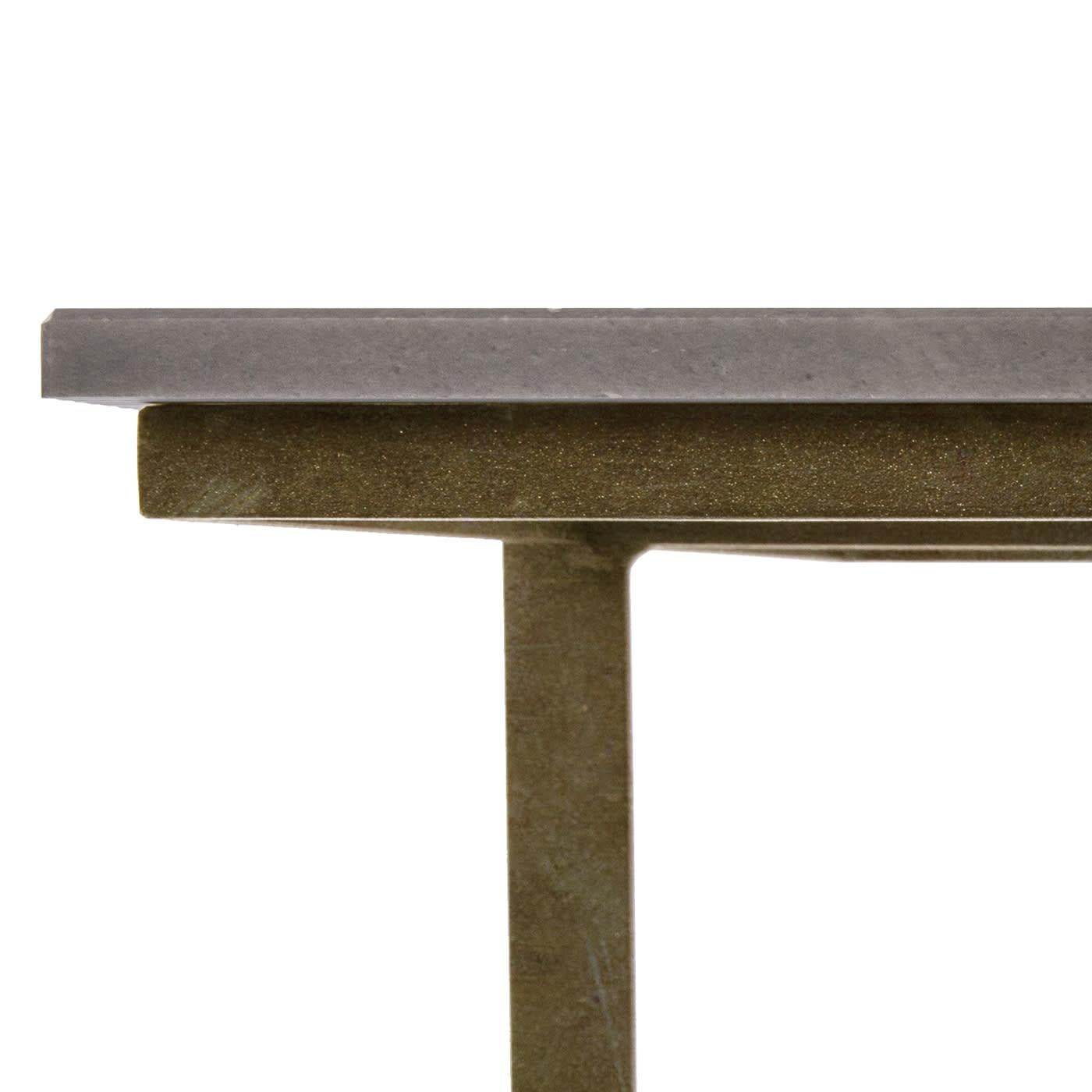 Le plateau en marbre à rayures olympiques fait de cette table basse fabriquée en Italie un meuble raffiné et rationnel à la personnalité séduisante. Le détail de l'articulation du plateau sur la structure métallique est mis en valeur par le