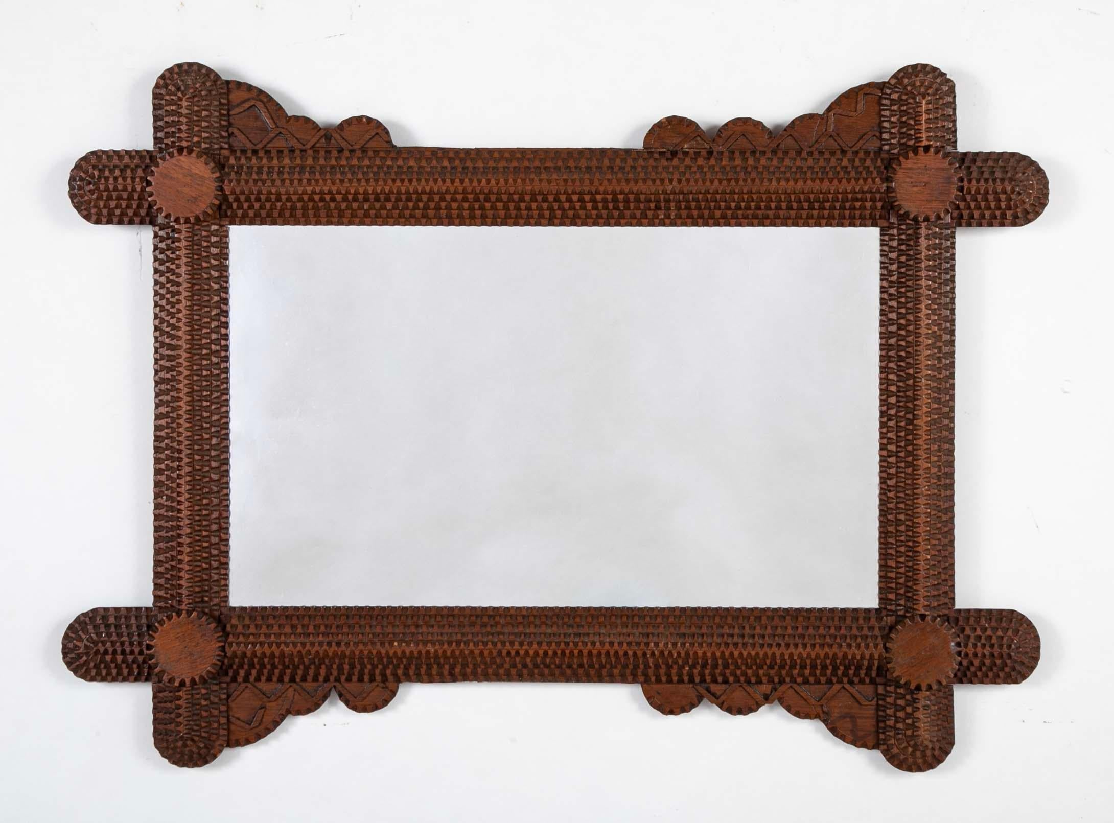 Tramp art frame of unusual form with circular and curved decorations on the corners. The labor intensive chip carving typical of this type of folk art is enhanced on this frame by the atypical rounded features, most are quite geometric. There is