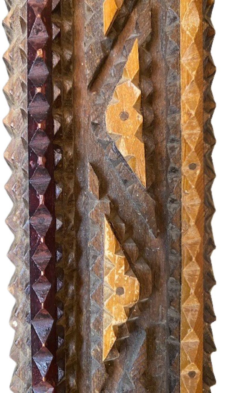 Antique Tramp Art Chip Carved Frame Mirror, circa 1920, a two tone chip-carved frame made by laying a graduated series of sawtooth-cut tiers one on top of another, creating a ridged frame with faux filet and applied triangles in a lighter color.