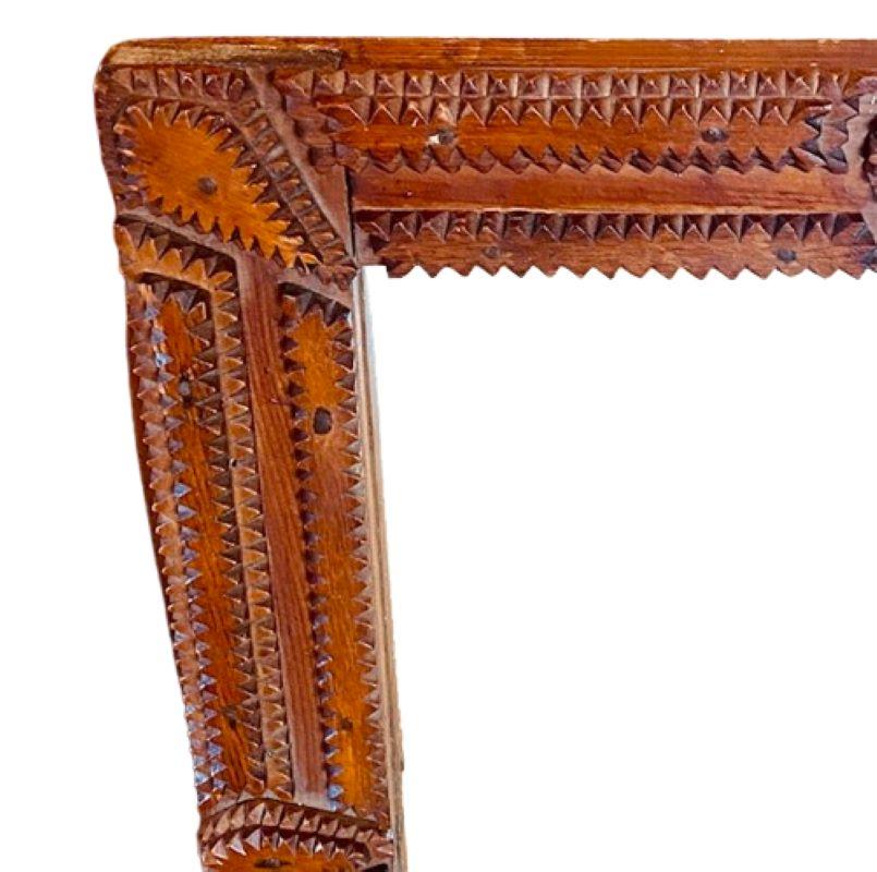 Antiker Tramp Art Chip Carved Spiegel, circa 1920er Jahre, ein handgefertigter Rahmen, der aus abgestuften Schichten von sägezahngeschnittenen dünnen Brettern besteht, die sich zu einem spitzen Grat erheben, mit aufgebrachten sägezahnumrandeten