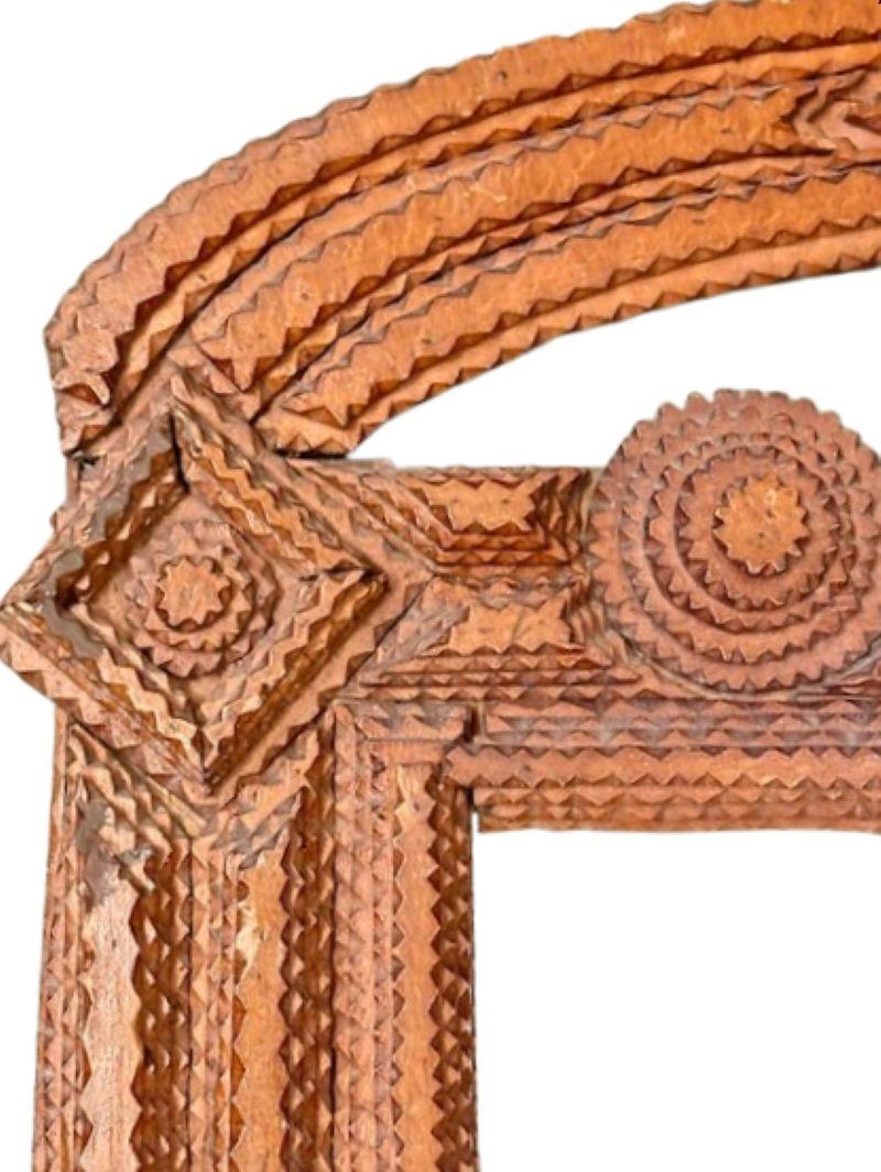 Cadre de miroir antique, daté de 1910, avec un sommet arqué sculpté et percé au-dessus d'un cadre rectangulaire, façonné avec des diamants multicouches et des yeux de bœuf, en finition légèrement vernie. 

Le mal nommé 