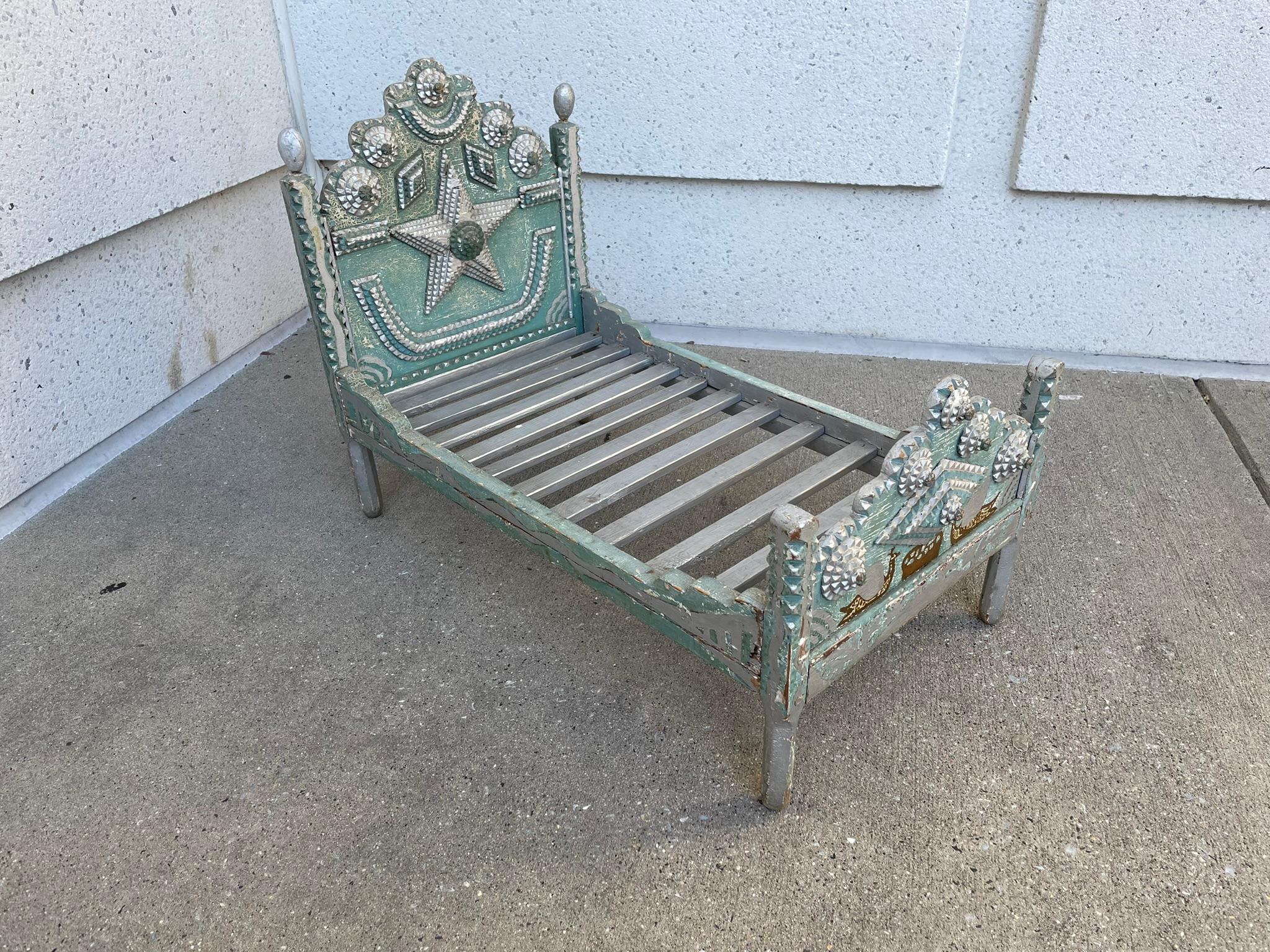 Rare, cool and unusual tramp art dog bed with chip carved decoration and blue and silver paint. The head board wonderfully carved with rosettes, diamonds and a large star in center. The foot board with a large diamond in center surrounded buy