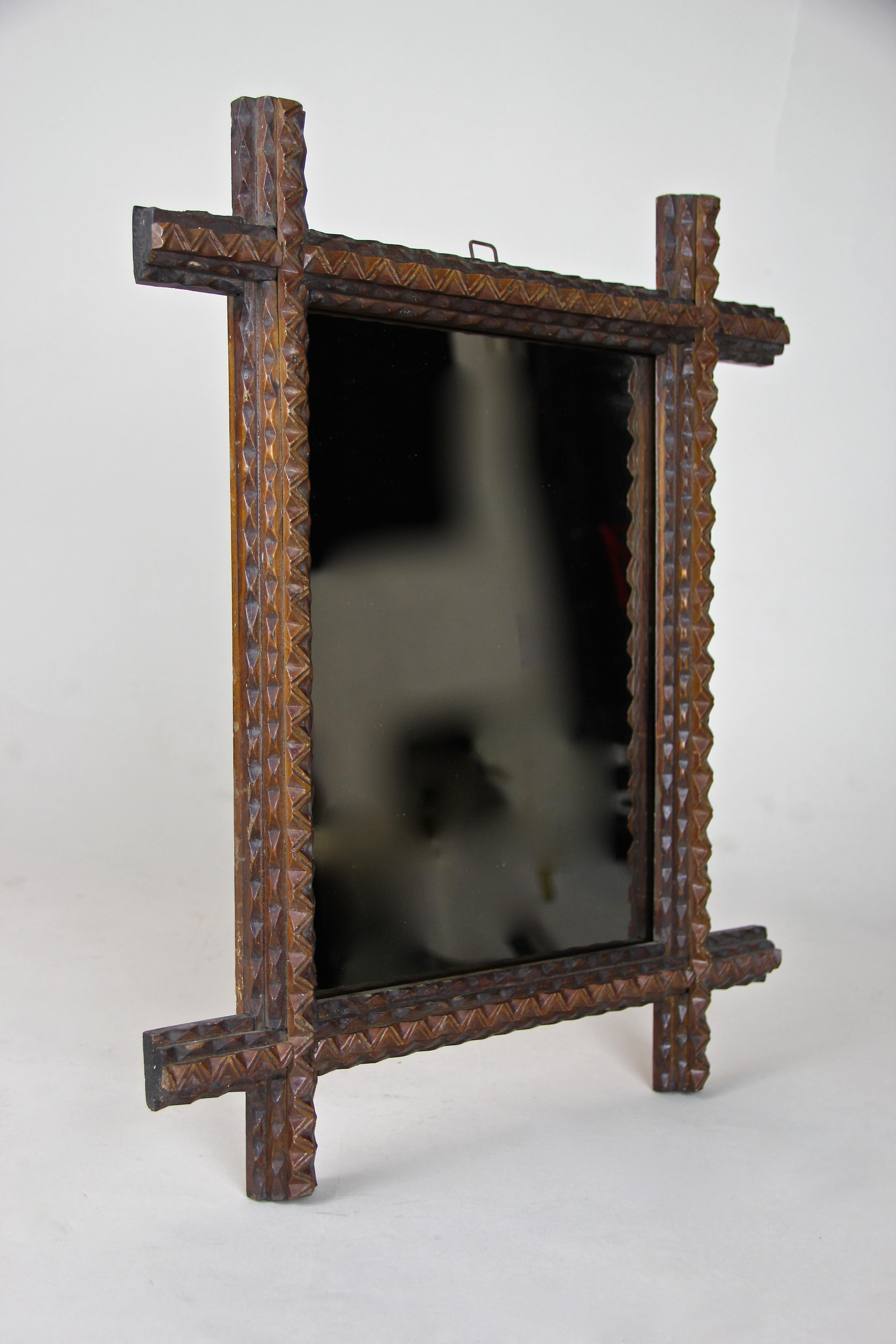 Beautiful small Tramp Art mirror from the late 19th century in Austria. Coming with a straight shape this wall mirror features the traditional pyramid-carved Tramp Art style out of basswood. The mirror glass had to be changed during restoration and