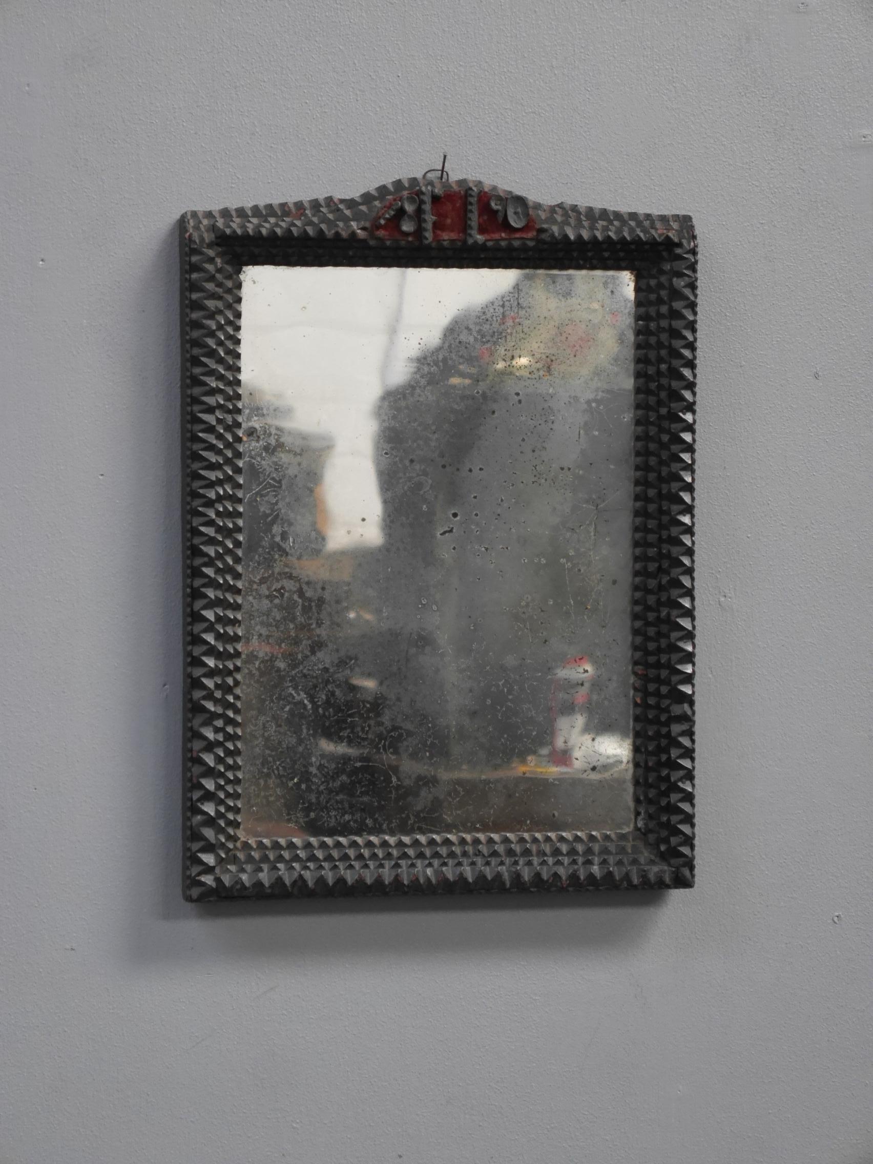 An early tramp art mirror.
A delightful piece of tramp art, the frame intricately layered & notch carved in the traditional manner, delightfully untouched, in the original finish & topped with a red velvet backed, dated panel. With a beautifully