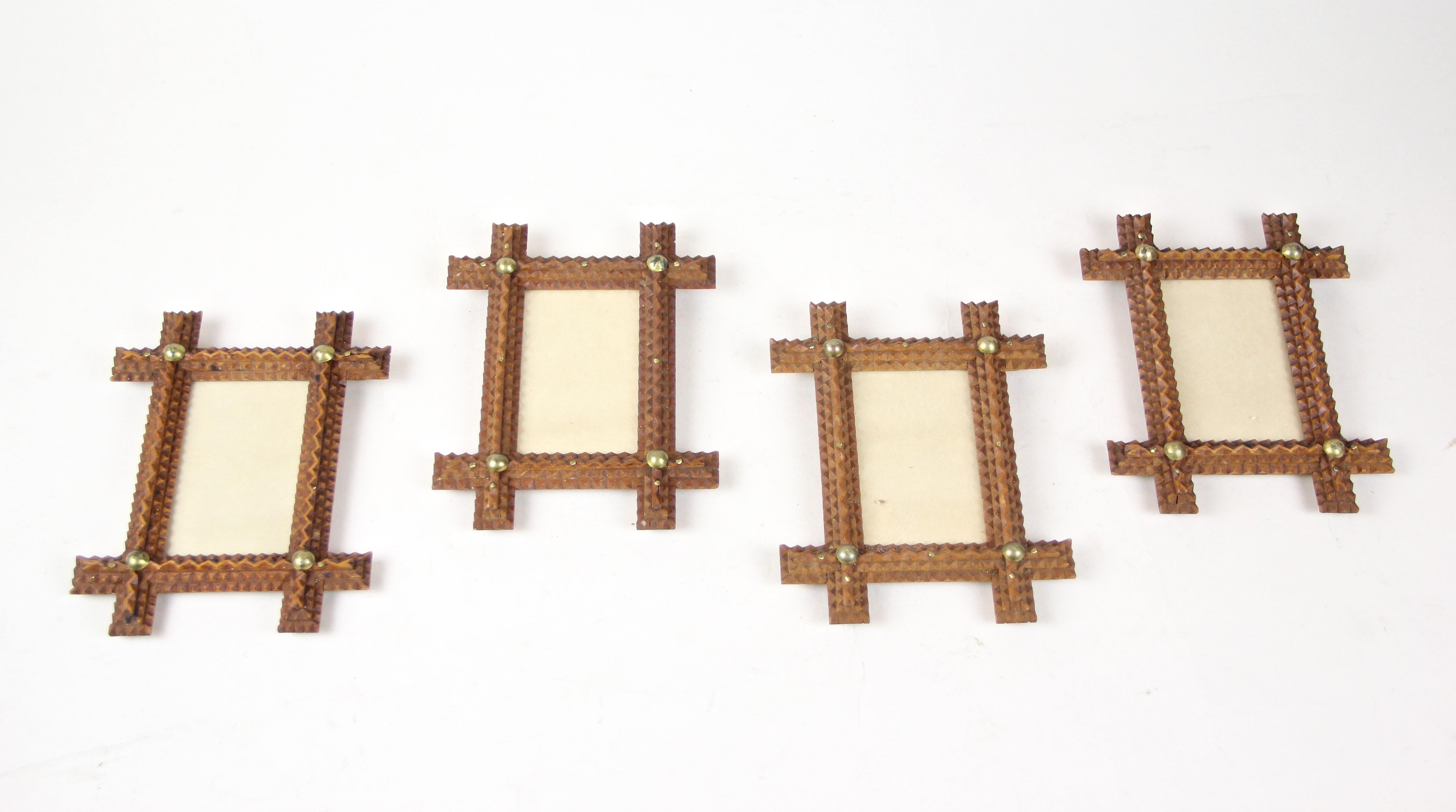 Lovely set of four small tramp art photo frames from circa 1890. Hand carved out of fine basswood, this beautiful Austrian frame set builds the perfect place for your unforgettable memories. The light brown frames show beautiful chip carvings and