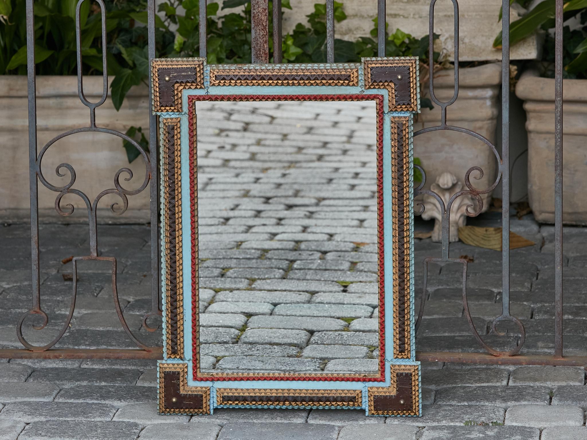 A French Tramp Art Turn of the Century polychrome hand-carved mirror from circa 1900 with protruding corners. This exquisite French Tramp Art mirror, crafted at the Turn of the Century circa 1900, embodies an intricate charm that resonates with