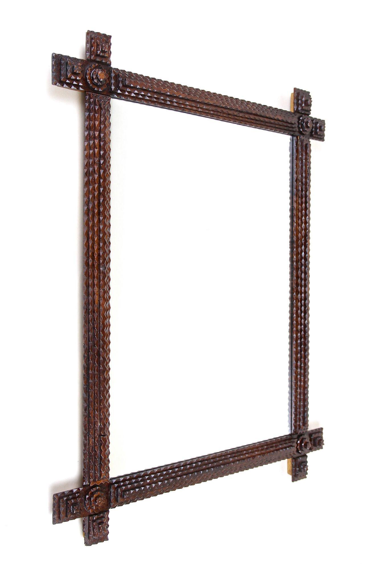 Unique handcarved Tramp Art Wall Mirror from the late 19th century in Austria. Artfully crafted around 1880, this extraordinary rustic wall mirror impresses with its extraordinary notch cut design and slightly protruding corners. The exceptional