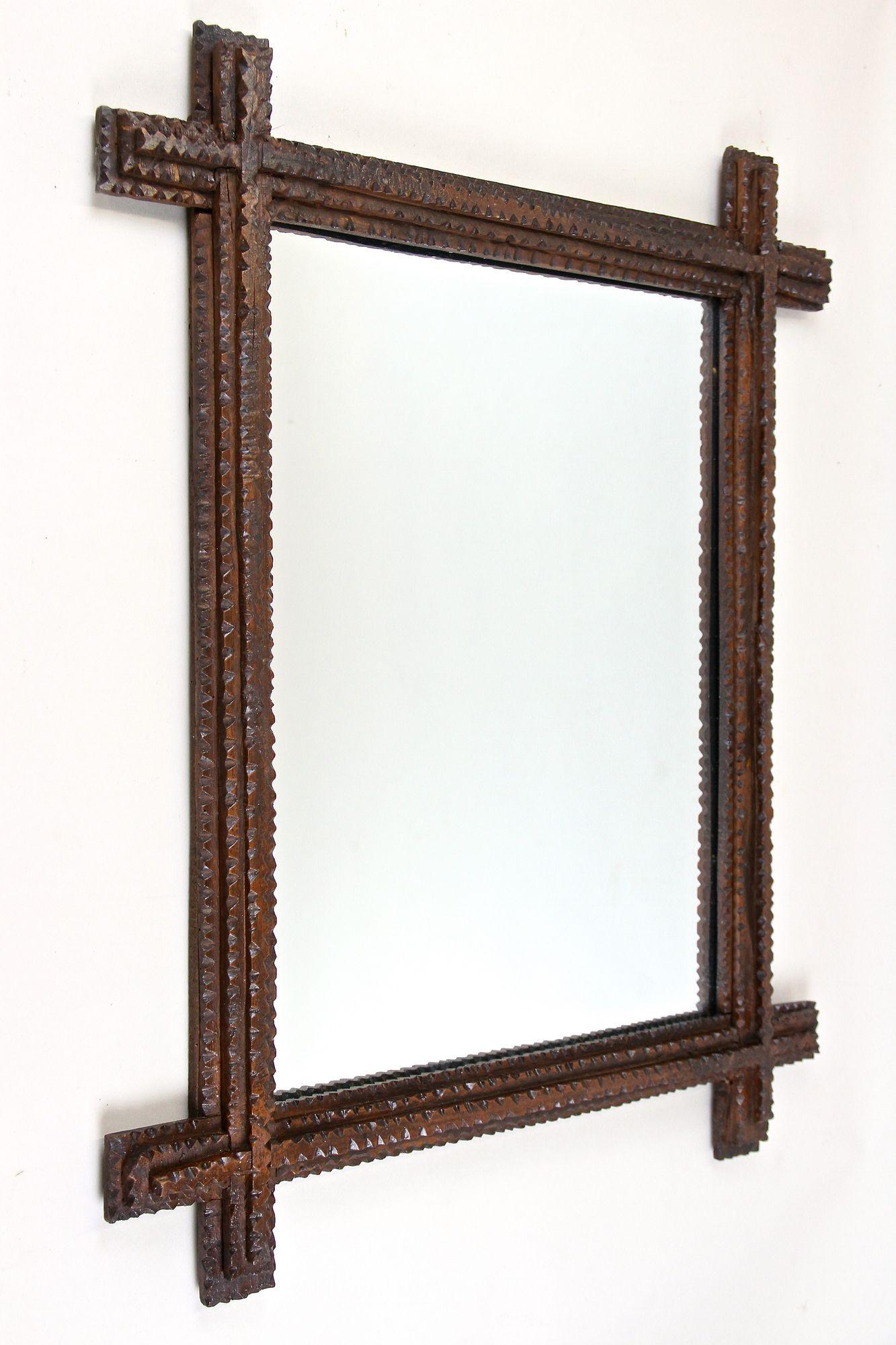 Beautiful rustic Tramp Art mirror from the 19th century in Austria. This unique rural wall mirror from around 1860 convinces by its great looking, unusual handcrafted design. The extraordinary chip carved frame confers this older example of a Tramp