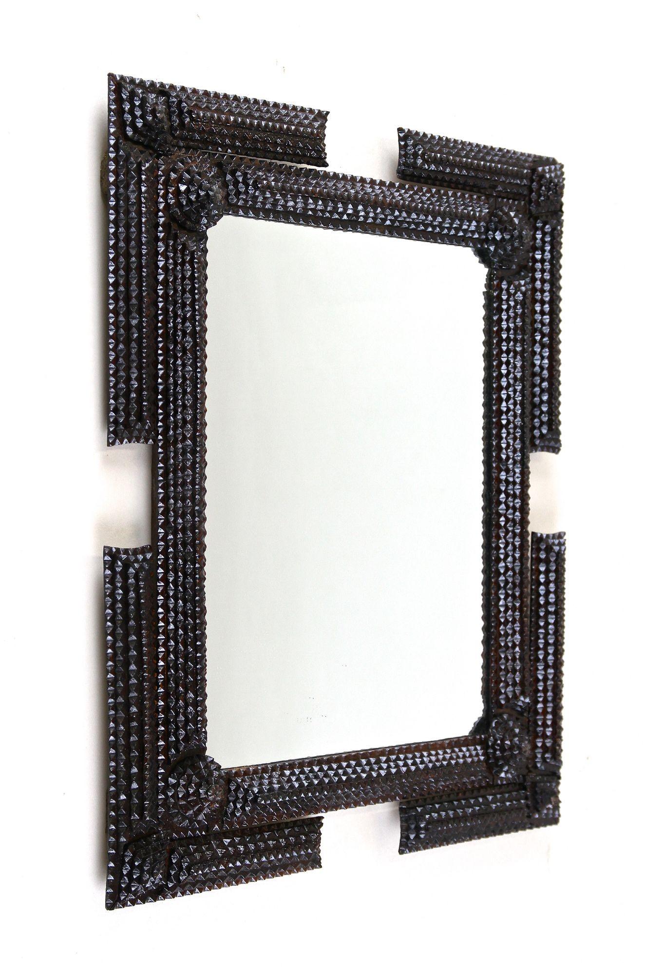 Extraordinary rustic Tramp Art wall mirror from the late 19th century period in Austria around 1870. This very elaborately hand carved mirror impresses with an exceptional designed frame which adorned by elaborately worked chip carvings. The