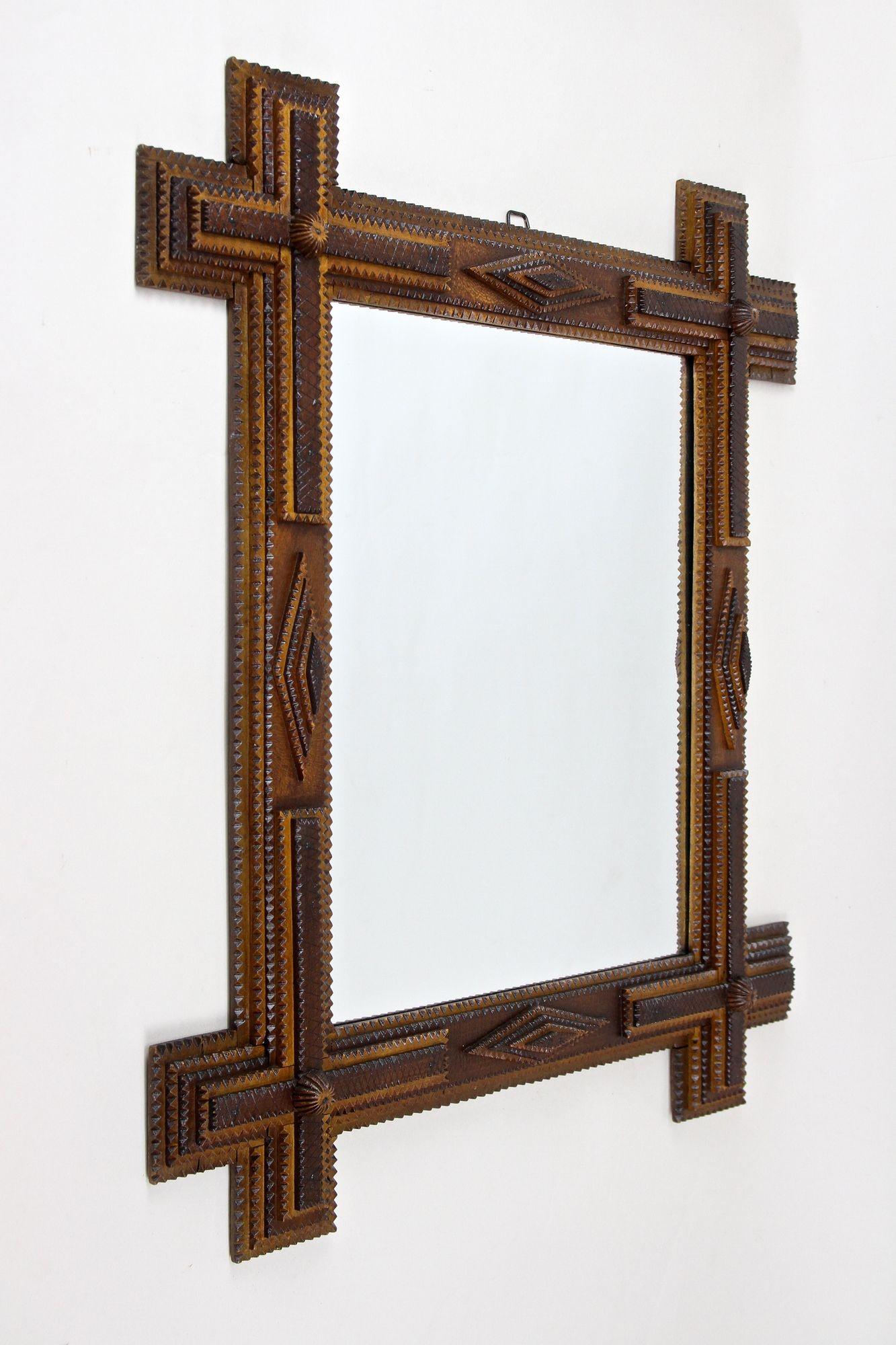 Exceptional looking rustic Tramp Art wall mirror from the late 19th century around 1890 in Austria. This very special crafted, elaborately made rural wall mirror impresses with its fantastic variety of different elements: chip carved 