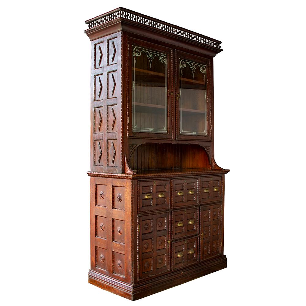 This beautifully refined tramp art cabinet is a show stopper. With its elegantly stenciled glass doors and delicate upper gallery rail, this is a piece of craftsmanship that goes above and beyond most Folk Art furniture. The handsome brass hardware