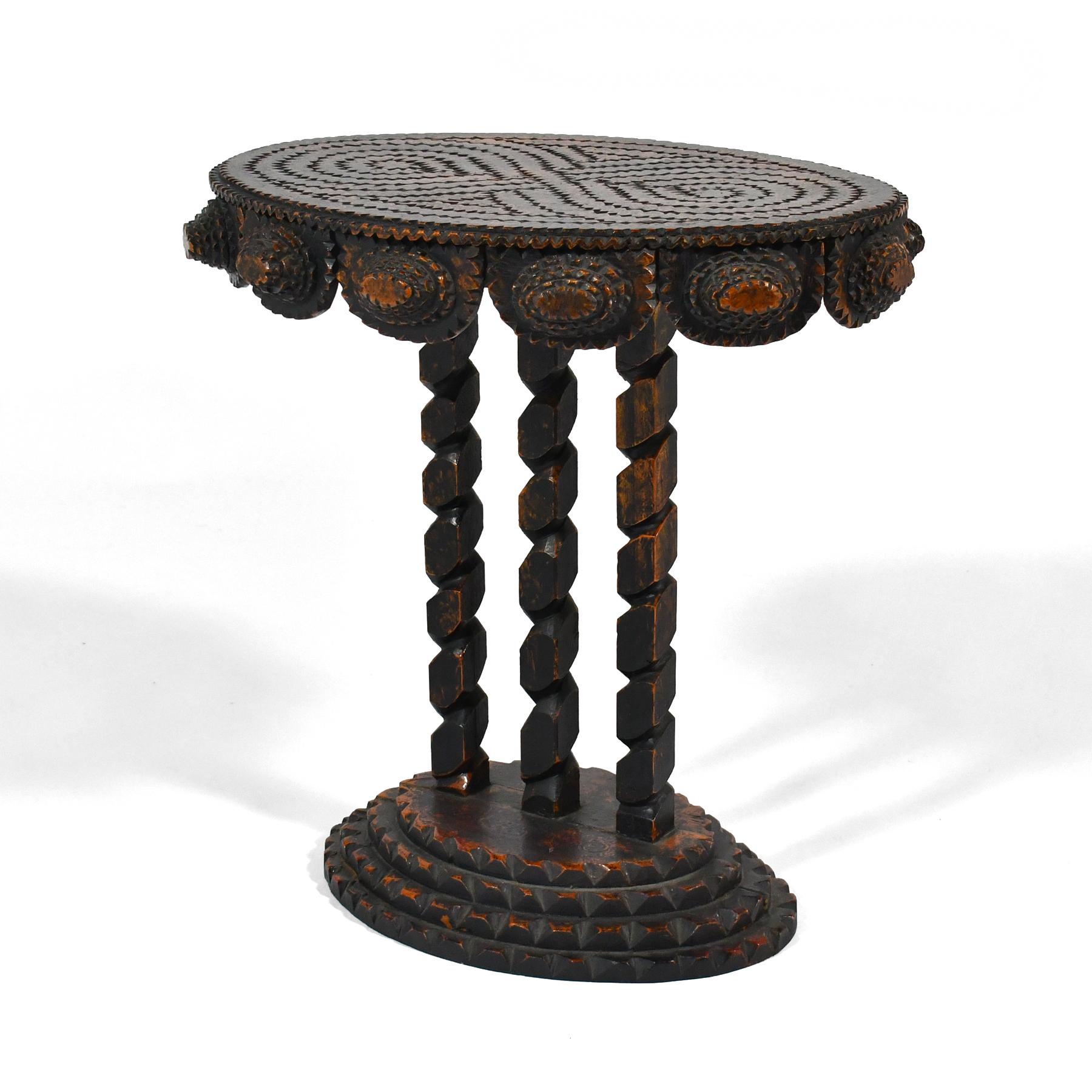 An exquisite example of tramp art with no surface left undecorated, this wonderfully carved tramp art table was made by the group known as the Hermitage Artists.  This group created quality examples of tramp art in the 1980s and were responsible for