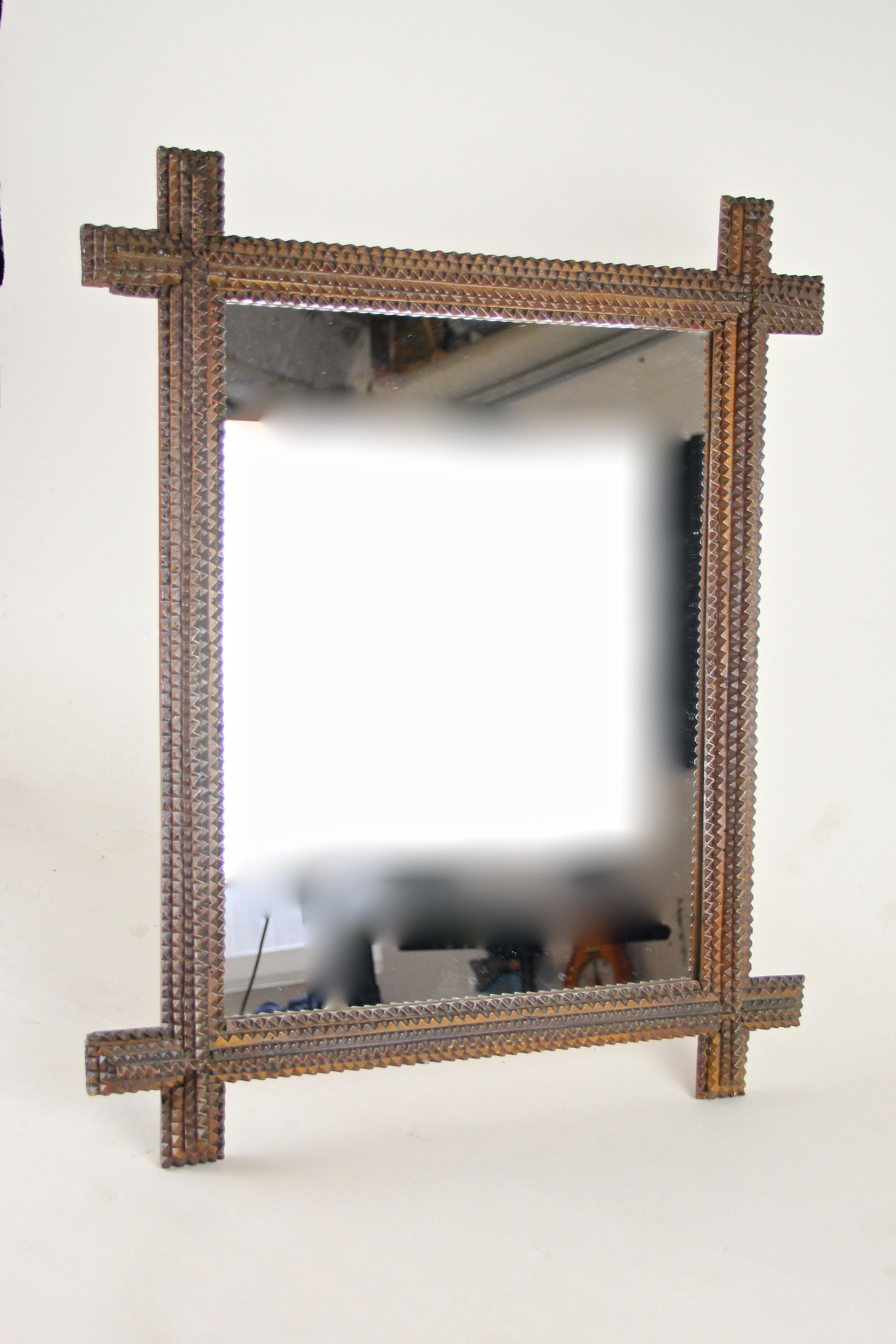 Unique carved Tramp Art Mirror from the second half of the 19th century in Austria. This rustic wall mirror from circa 1880 has been artfully hand carved out of basswood and comes with a light shellac finished surface. The mirror glass has been
