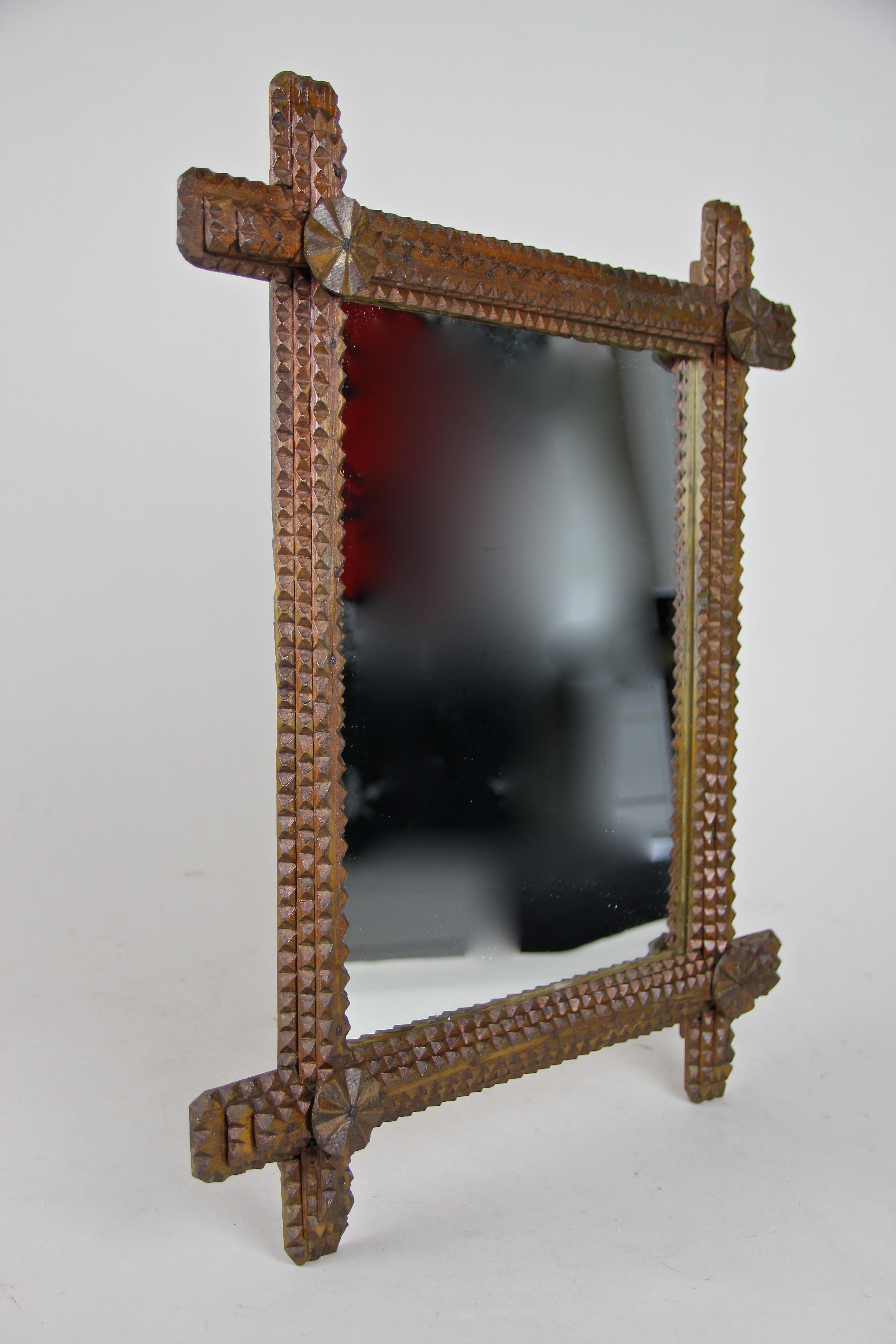 Delightful wooden Tramp Art wall mirror from circa 1870 in Austria. This late 19th century hand carved mirror comes with a lovely rustic design adorned by round wooden applications in the corners, looking like small wind turbines. A unique shape