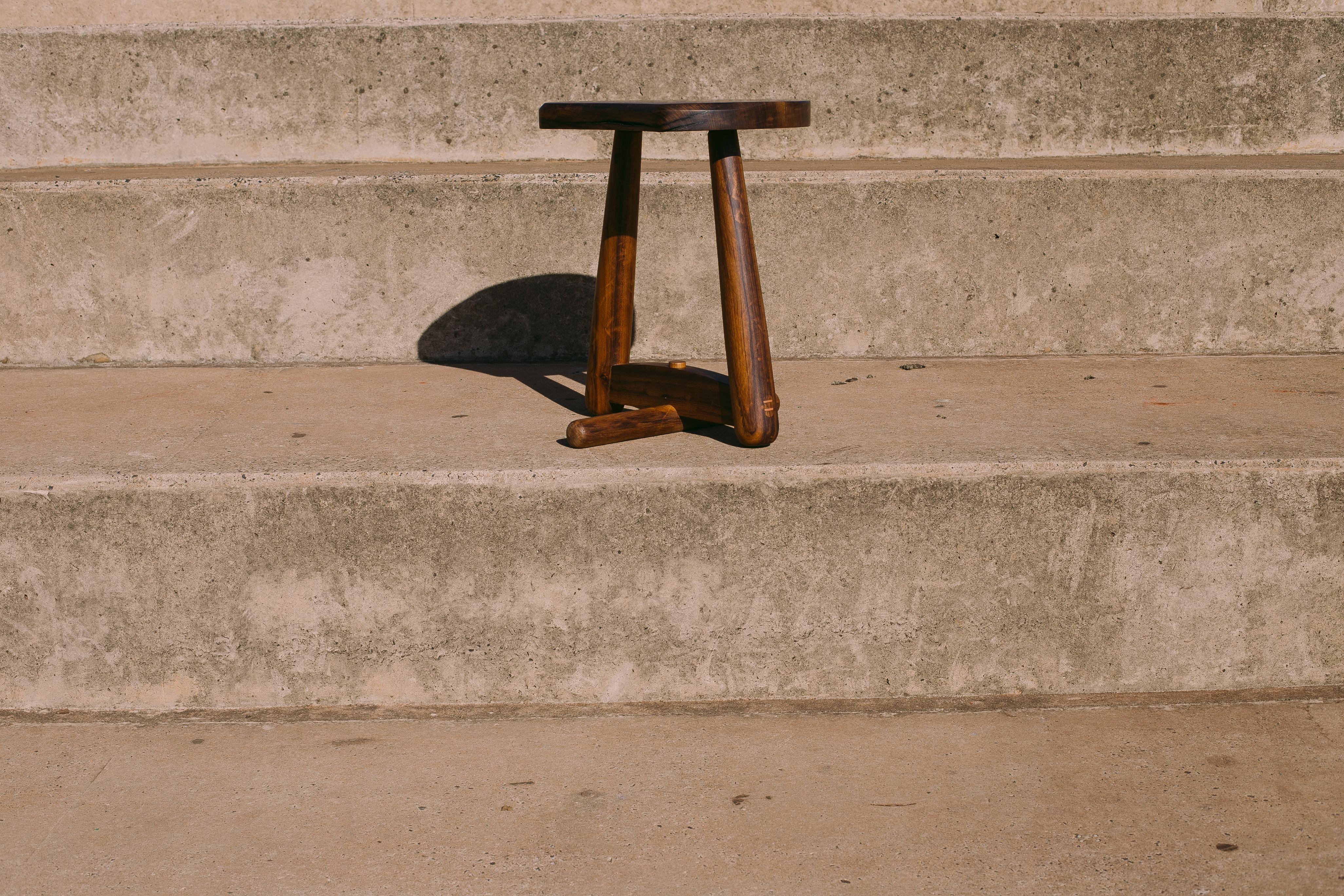 The stool is made of solid wood braced in studs with wedges, evidencing the traditional carpentry. The piece stands out by the structure in only two legs allied to a turned cylindrical base. At first, the piece presumes imbalance, which generates