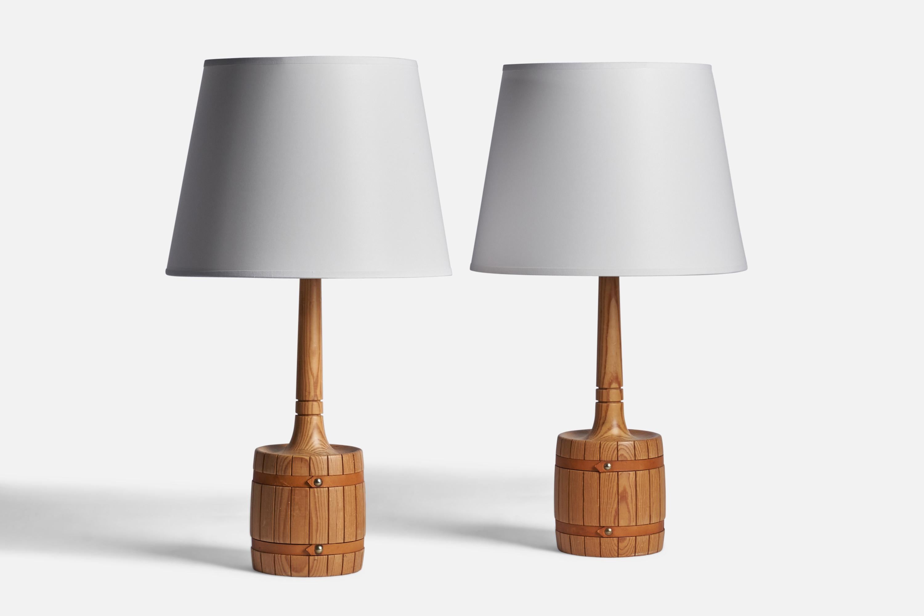 A pair of pine, leather and brass table lamps designed and produced by Tranås Stilarmatur, Sweden, 1970s.

Dimensions of Lamp (inches): 16“ H x 5.25” Diameter
Dimensions of Shade (inches): 9” Top Diameter x 12” Bottom Diameter x 9” H 
Dimensions of