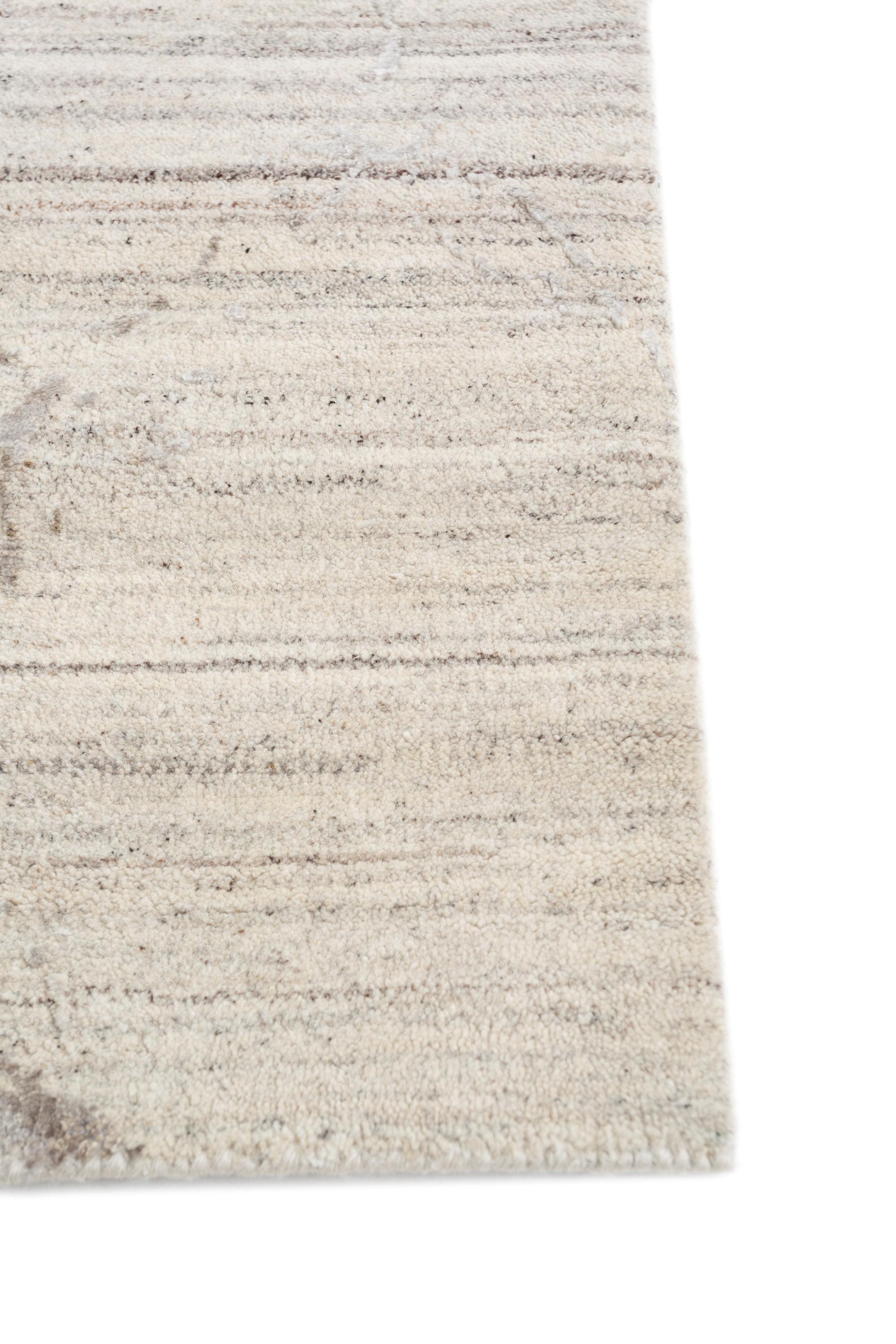 Embark on a journey of serenity with this hand-knotted rug  featuring abstract designs that echo the unrushed quality of natural processes. Designed to inspire a step away from the rush, its white chalk base and shale border create a calming oasis.