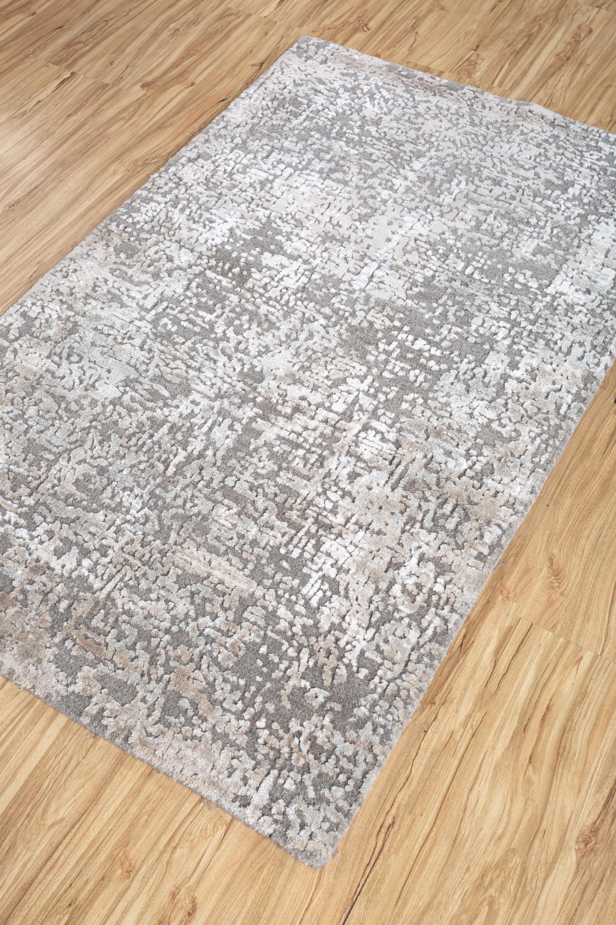 Immerse your space in the subtlety of this hand-knotted rug by Jaipur Rugs, which is nothing less than a modern marvel transcending conventional design. It is handcrafted with precision from a blend of wool and bamboo silk. The color scheme of