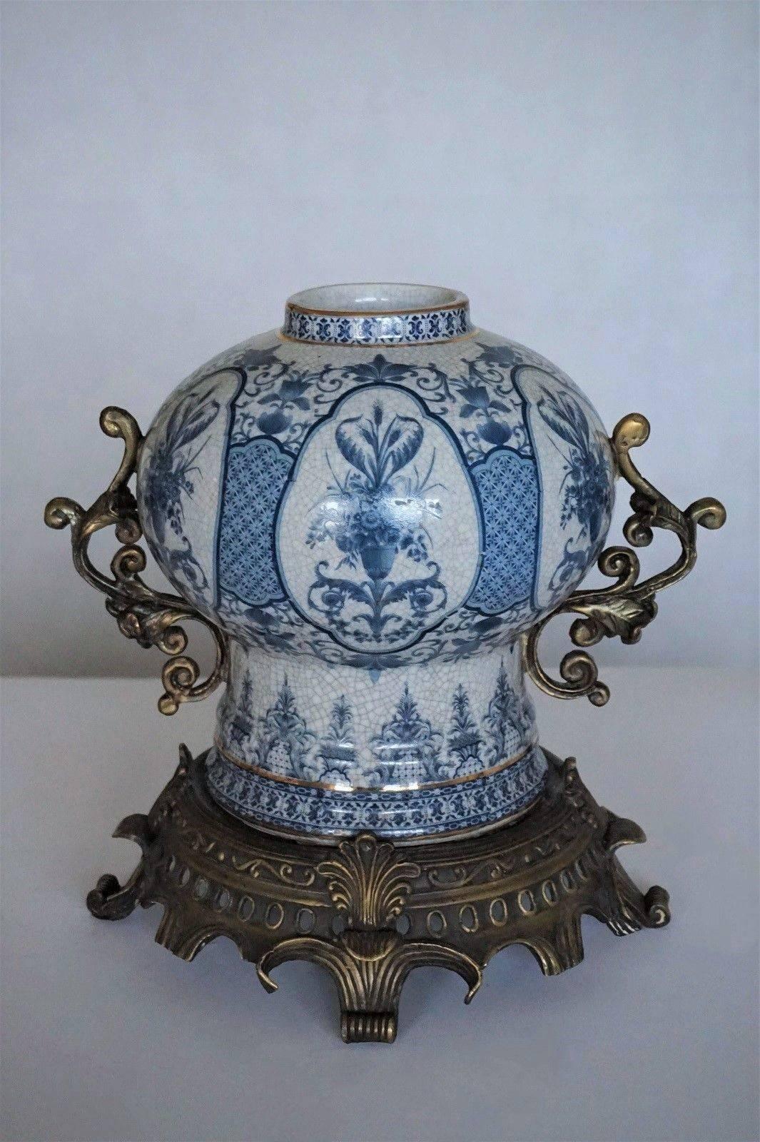 Transfer decorated chinoiserie blue and white porcelain globular jar with bronze handles and stand, late 19th century. White porcelain hand painted in brilliant blue with floral panels and glazed.
Measures:
Height including bronze stand 12 in (30