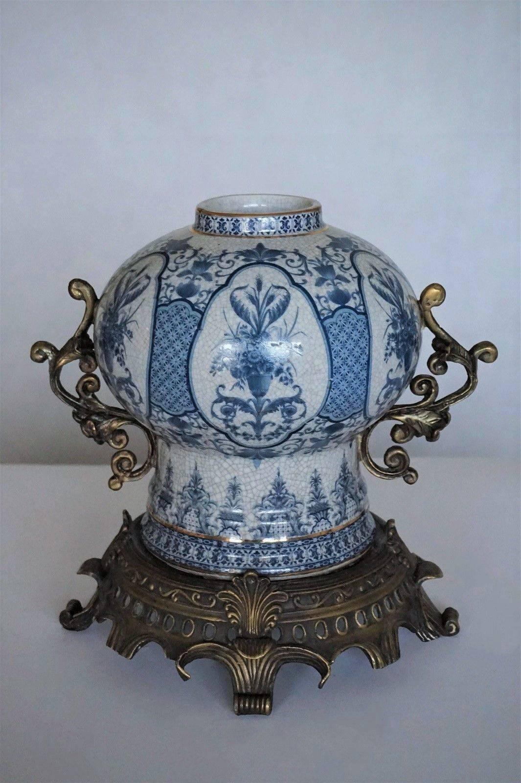 Vaso globulare in porcellana blu e bianca decorata a trasferimento con manici in bronzo e supporto, fine del XIX secolo. Porcellana bianca dipinta a mano in blu brillante con pannelli floreali e smaltata.
Misure:
Altezza, compreso il supporto in
