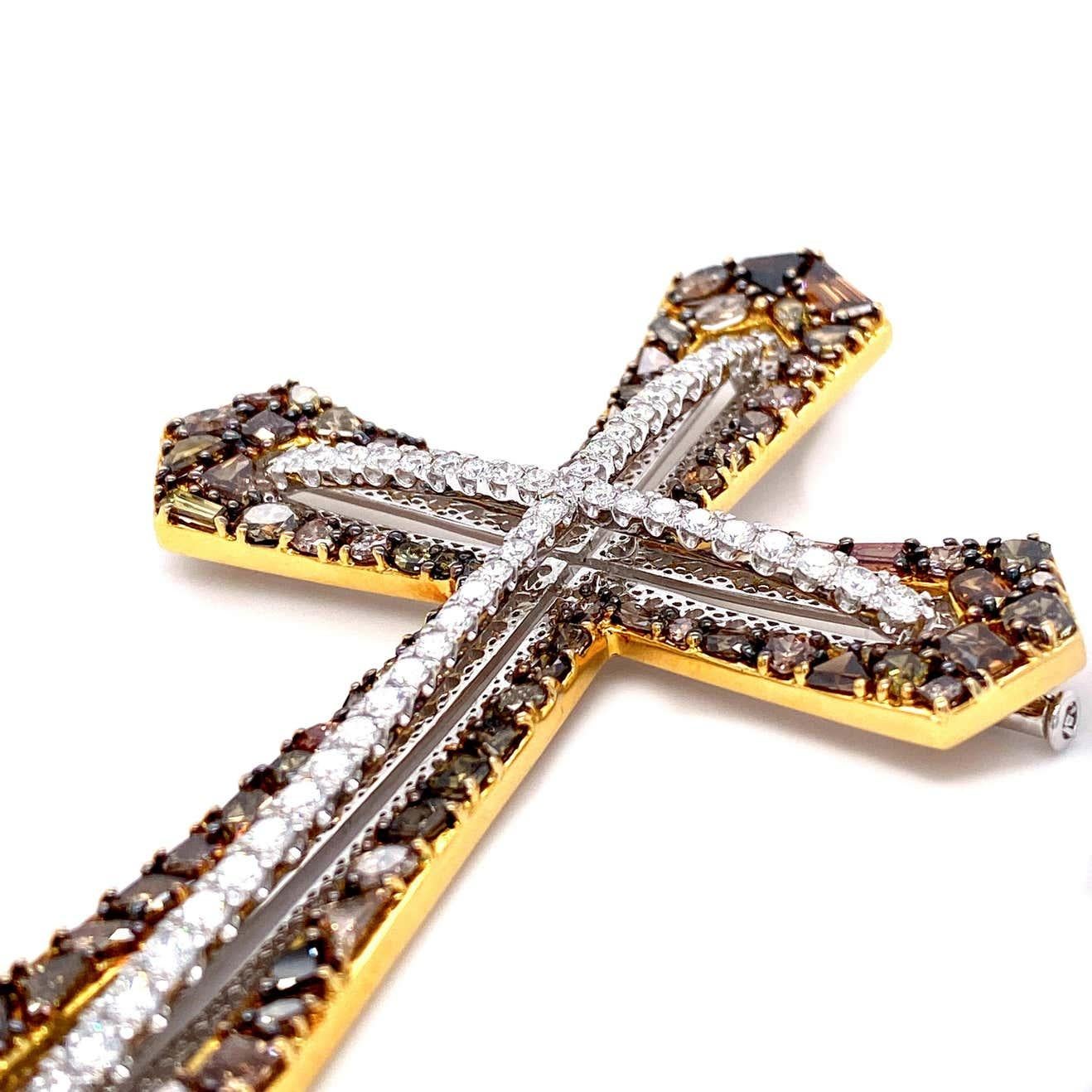 A bold statement piece, this diamond-embellished cross is artfully composed of a unique mix of white and fancy colored diamonds, which range from browns to yellows, totaling 11.38 carats. This piece is also transformable from a brooch to a pendant,