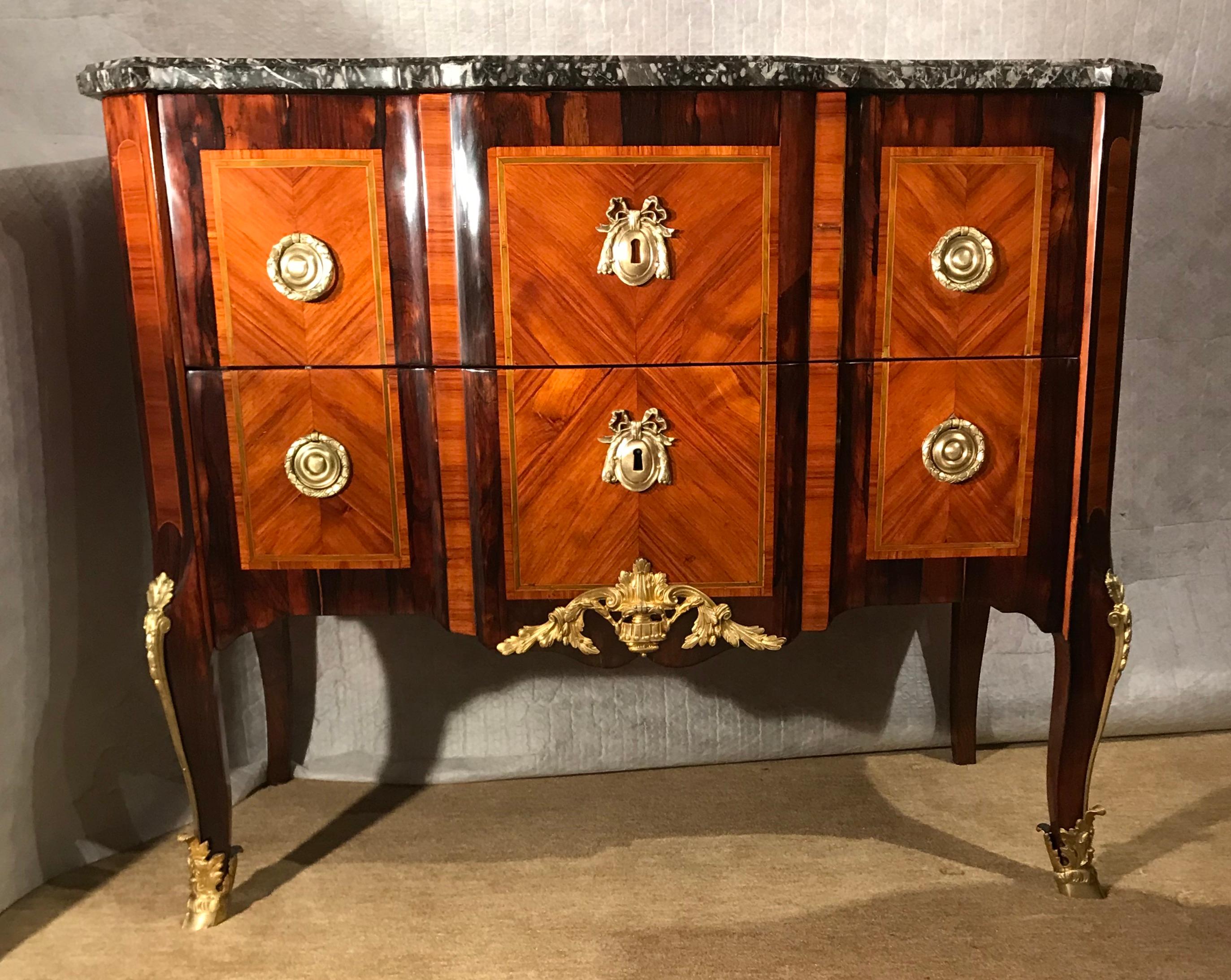 Transition commode, France 1770. 
Exquisite satinwood and king wood veneer with delicate green colored wood inlays framing the satinwood parts. Original brass and bronze fittings and marble top. This is a wonderful example of the high craftsmanship