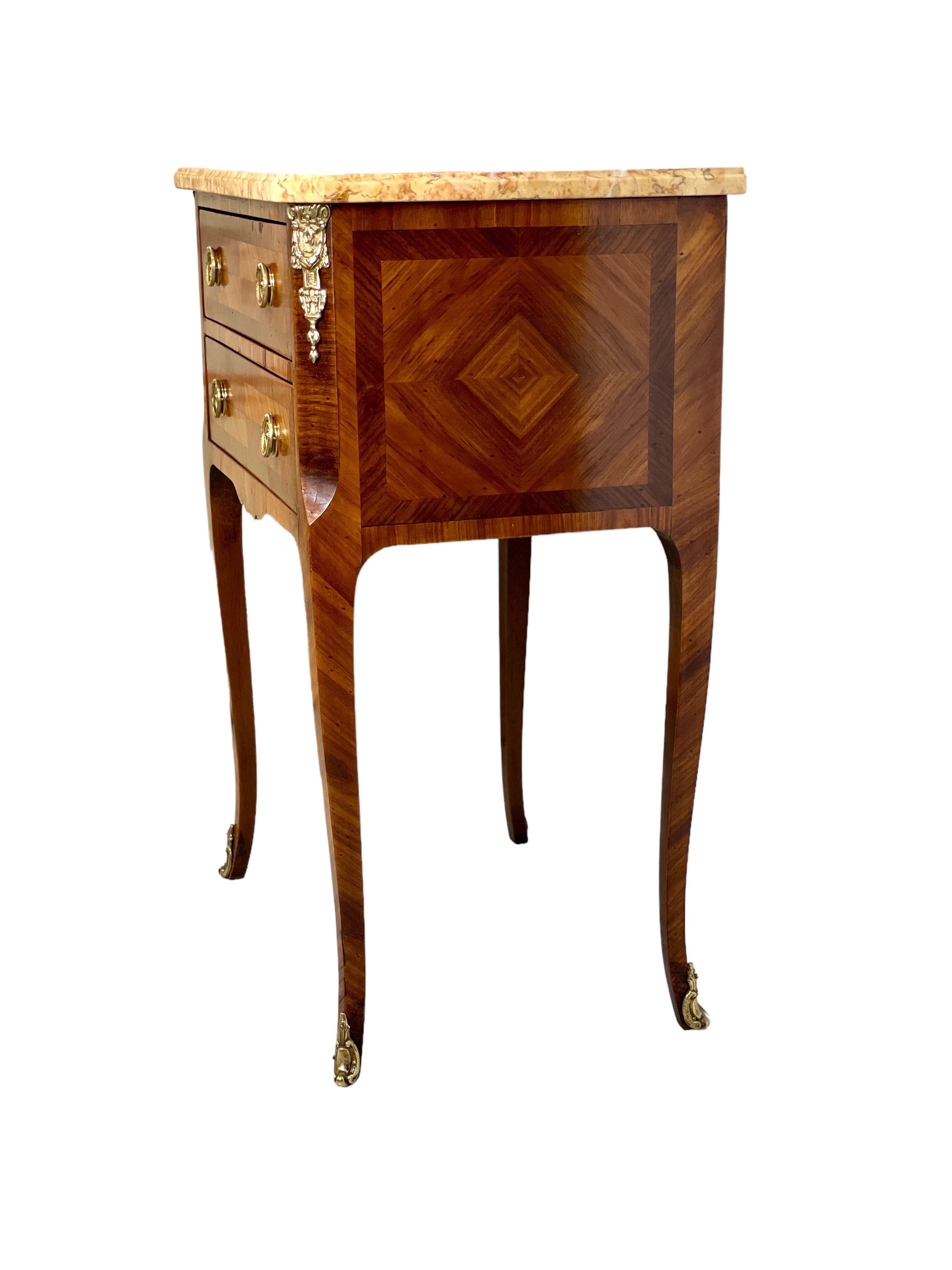 A charming French transitional style 'table de chevet', or bedside table, the façade of which features two drawers magnificently inlaid with a diamond motif across their fronts. The sides are also inlaid with fabulous diamond-shaped veneers, and the