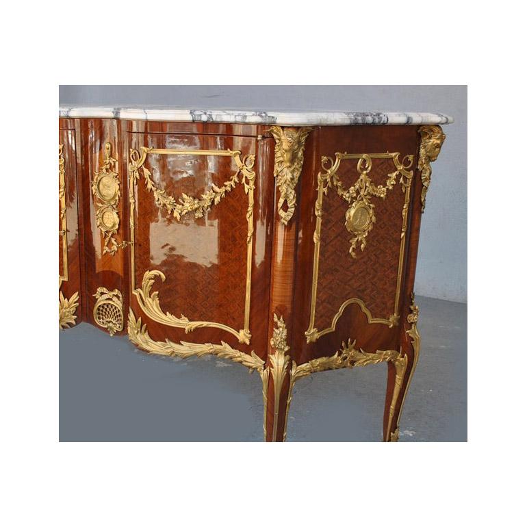 Sideboard inlaid in Transition style richly decorated with gilded bronzes on white marble top veined with double Corbin beak. Geometric marquetry decorations. This chest of drawers dates from the second half of the 20th century and comes from a
