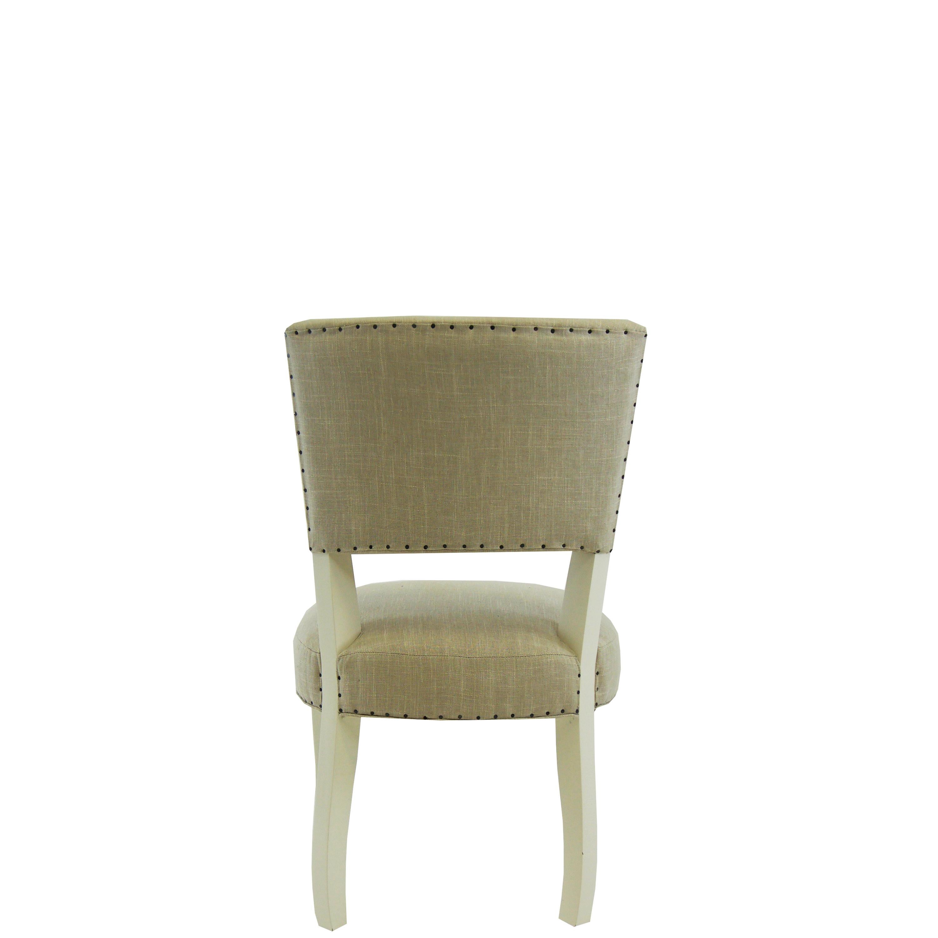 This transitional armless dining chair features a toned down cabriole leg. Comes standard with smoke colored linen and antiqued grey finish. This built to order chair is completely customizable in any finish and fabric*. This piece is handmade from
