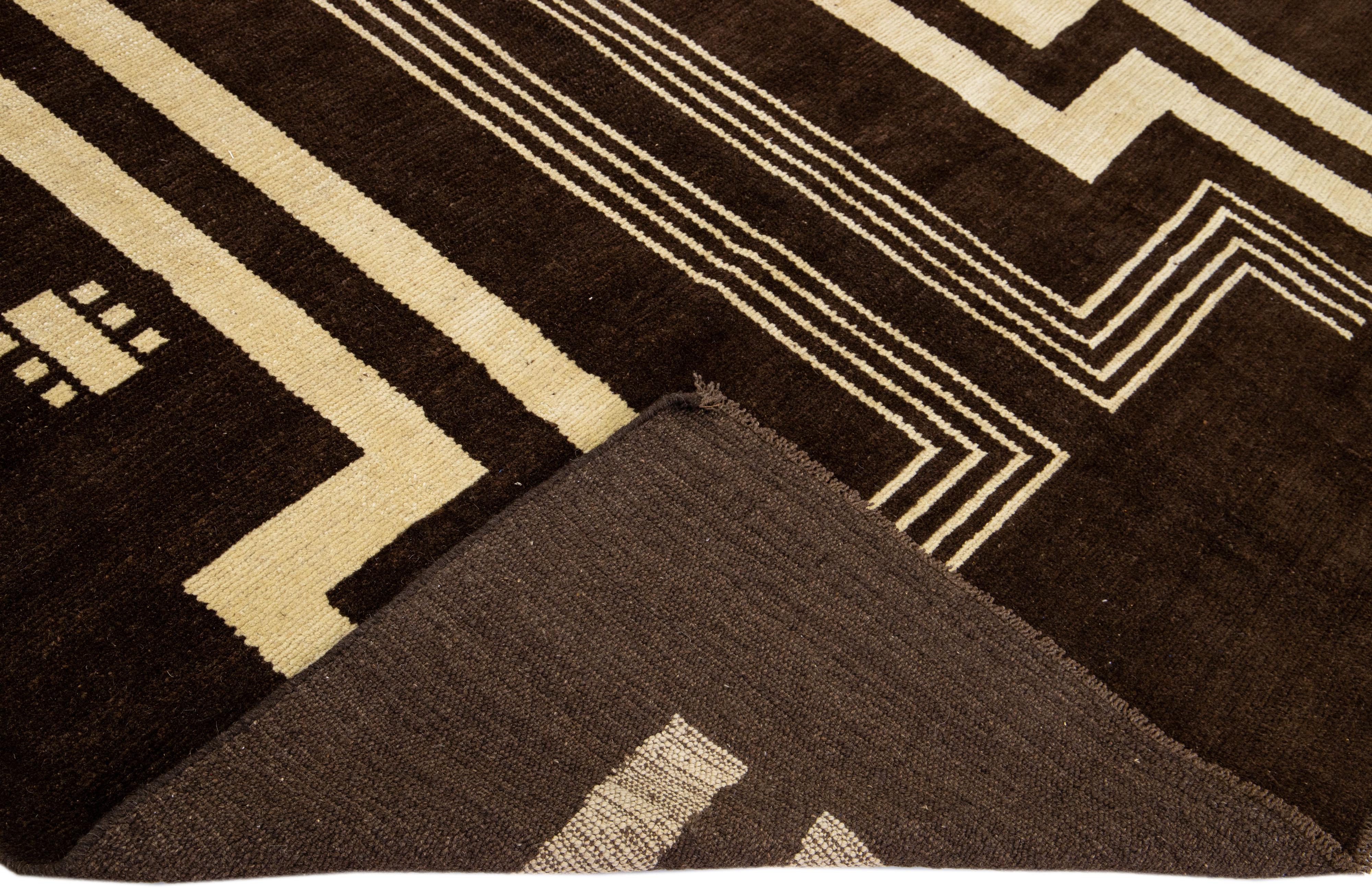 This Beautiful Modern Art Deco handmade wool rug makes part of our Northwest collection and features a dark brown color field and beige accents in a gorgeous geometric tribal design.

This rug measures: 7' x 9'.

Our rugs are professional