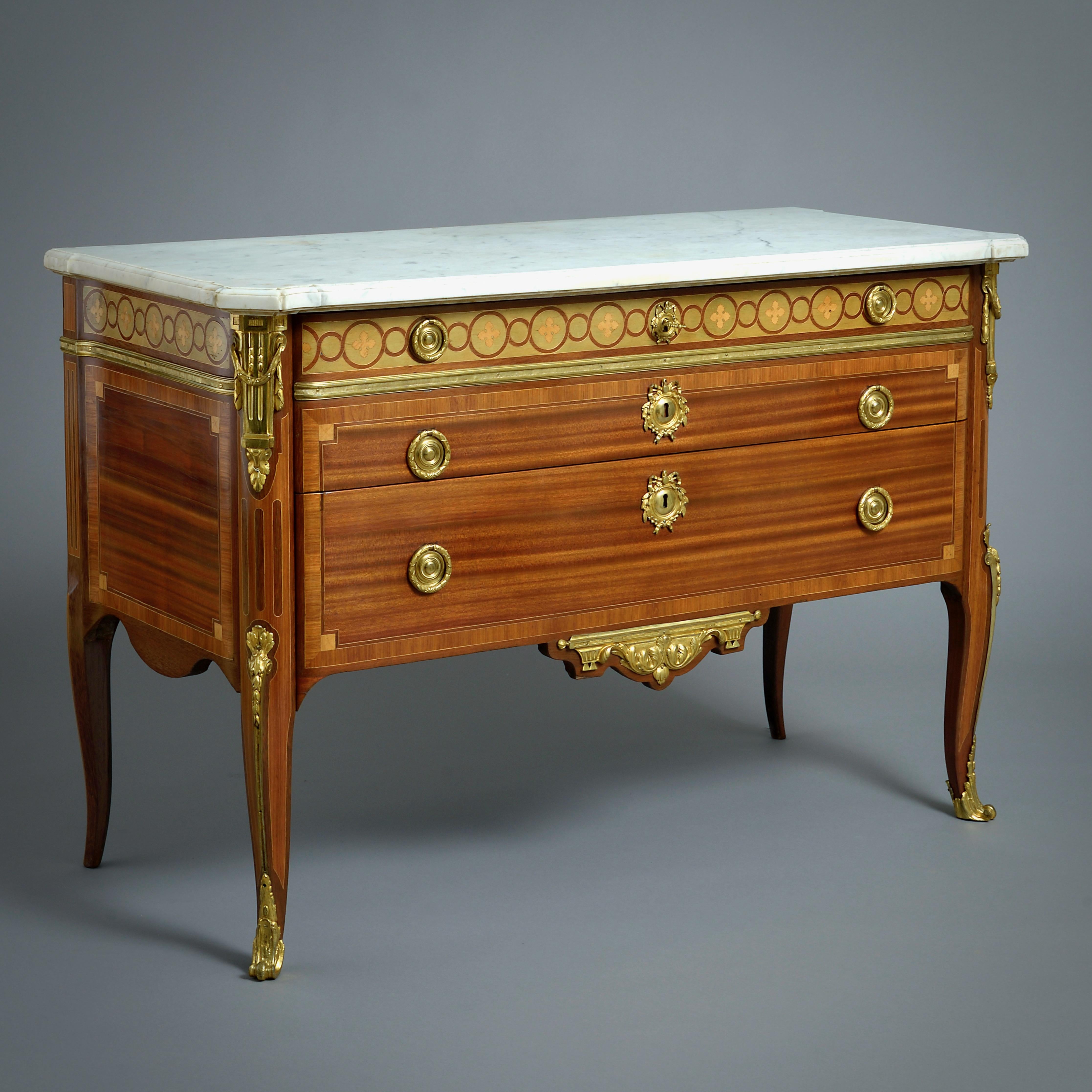 UNE BELLE COMMODE DE TRANSITION EN BOIS-SATINÉ ET MARQUETERIE, MONTÉE SUR BRONZE DORÉ, PAR JEAN-BAPTISTE TUART ET FERDINAND BOI, VERS 1770.

Le plateau en marbre de Carrare moulé et orné d'une oreille est surmonté de deux longs tiroirs. Tous les