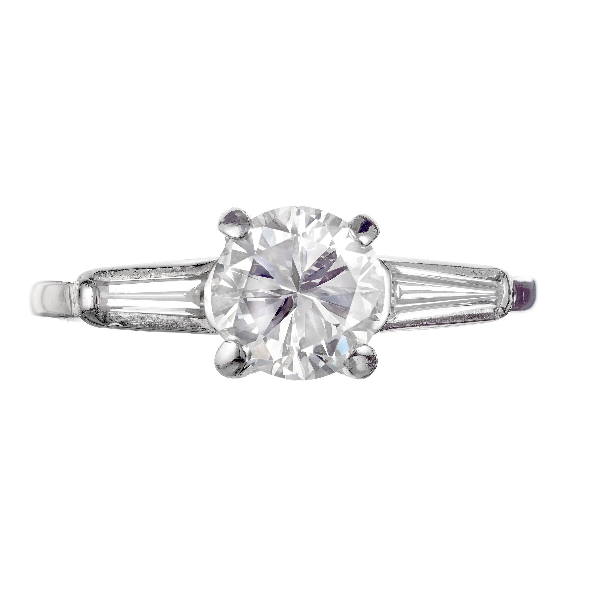 Mid-Century Transitional brilliant cut round center diamond engagement ring. Set in platinum with two tapered baguette side diamonds in a three-stone setting. 

1 transitional cut round diamond, approx. total weight 1.03cts, F-G, VS1, Depth: 62.9% 