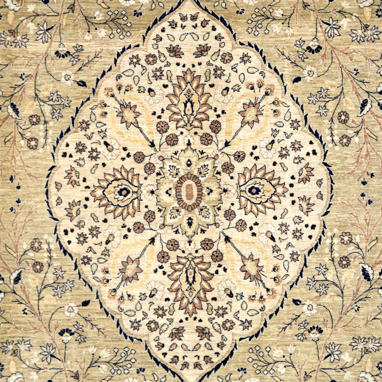 With bold indigo details outlining blooming floral designs, this ivory Kashan Mohtashan carpet measures 9’ x 12’6” and belongs to the Orley Shabahang Transitional collection. Inspired by the lavish Shah Abbas Persian garden, its design depicts a