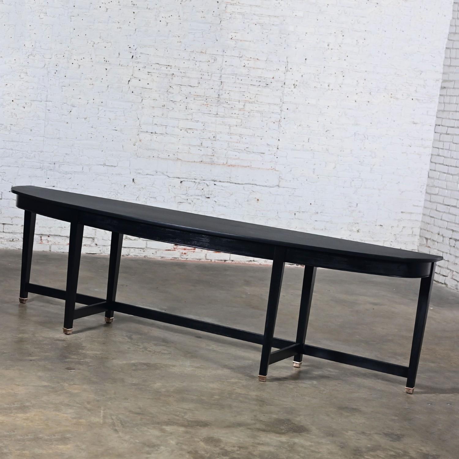 Magnifique console de style Transitional Monumental en acajou démilune avec une finition peinte en noir, des pieds fuselés carrés avec des étirements, et des pieds en laiton patiné de 2 pouces. Byit, en gardant à l'esprit qu'il s'agit d'une pièce