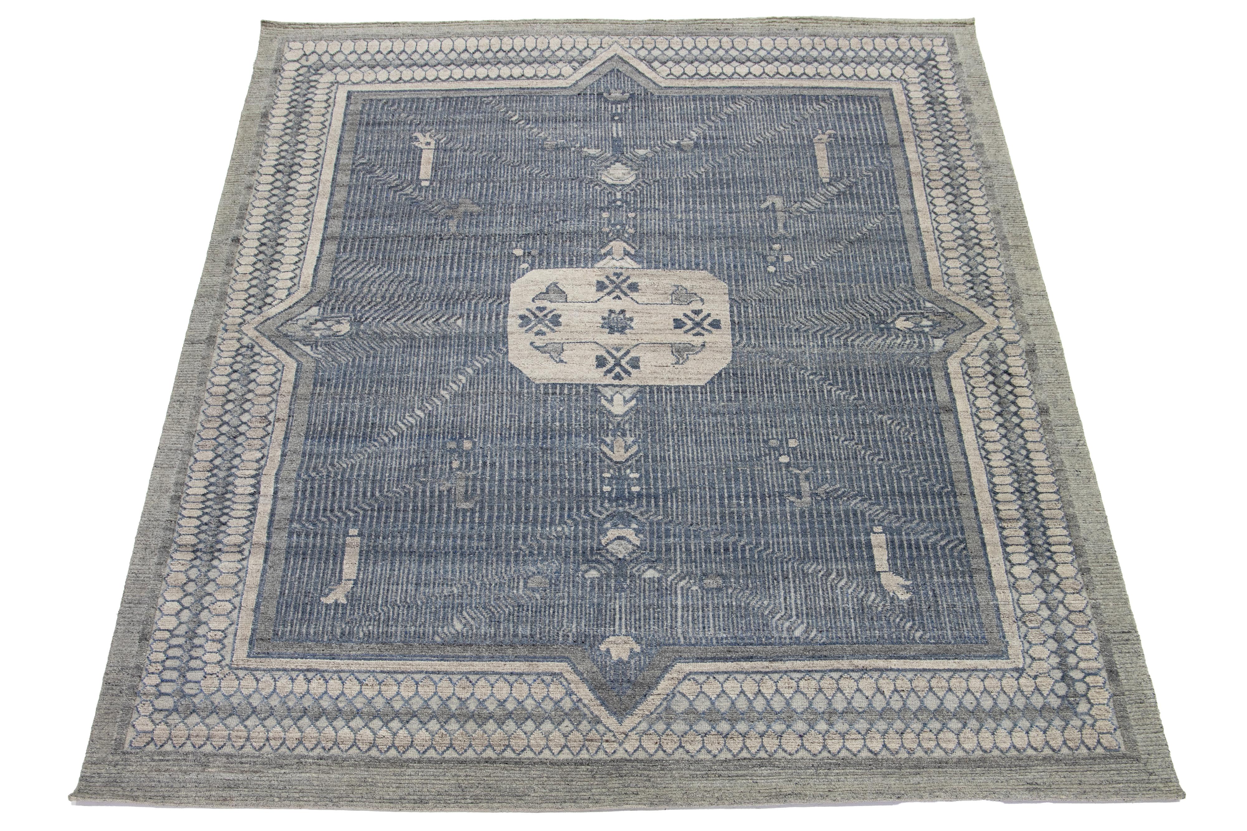 Questo bellissimo tappeto moderno di transizione in lana annodato a mano in stile Oushak presenta un sorprendente disegno a medaglione grigio e blu arricchito da accenti grigio chiaro.

Questo tappeto misura 9'3'' x 11'10''.

 