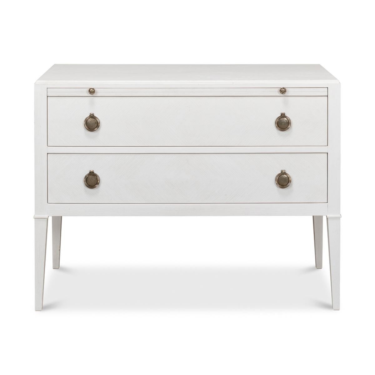 In the French Louis XVI style, the transitional painted oak dresser has a herringbone pattern in our working white finish, with a long dressing slide above two long drawers, with brass hardware and raised on square tapered legs. 

Dimensions: 38