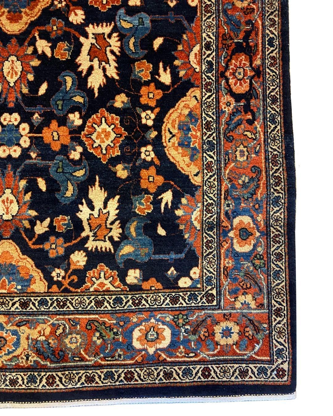 This hand-knotted transitional Persian carpet, in indigo, red, and blue wool measures 4' x 6' and blends classic Persian elegance with a bold, contemporary flair. Woven entirely by hand using handspun wool and naturally dyed fibers, this piece