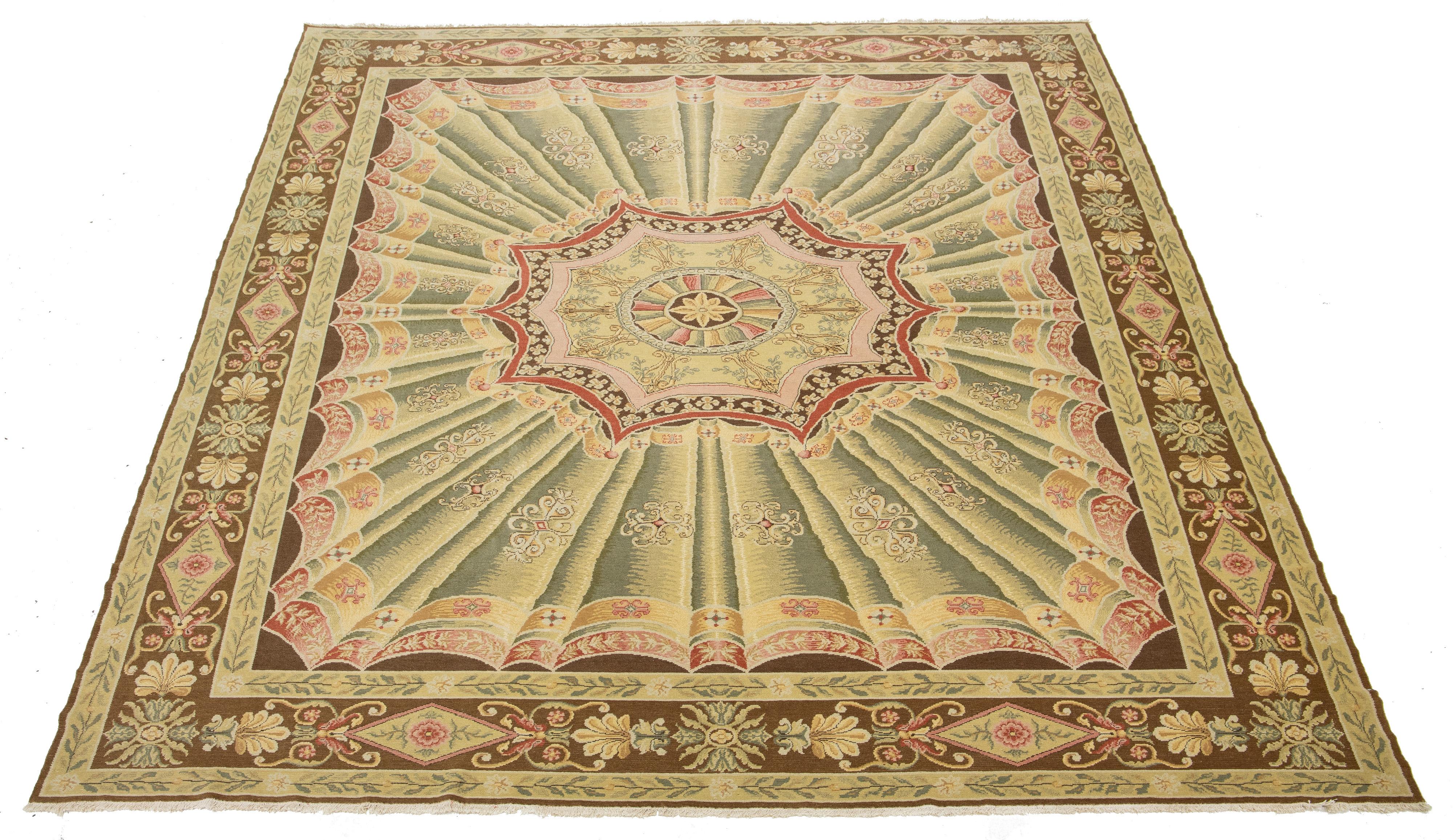 Bellissimo tappeto in lana Savonnerie annodato a mano in stile antico con un campo di colori beige e verde salvia. Questo pezzo ha una cornice marrone disegnata e accenti multicolore in uno splendido motivo floreale a medaglione.

Questo tappeto