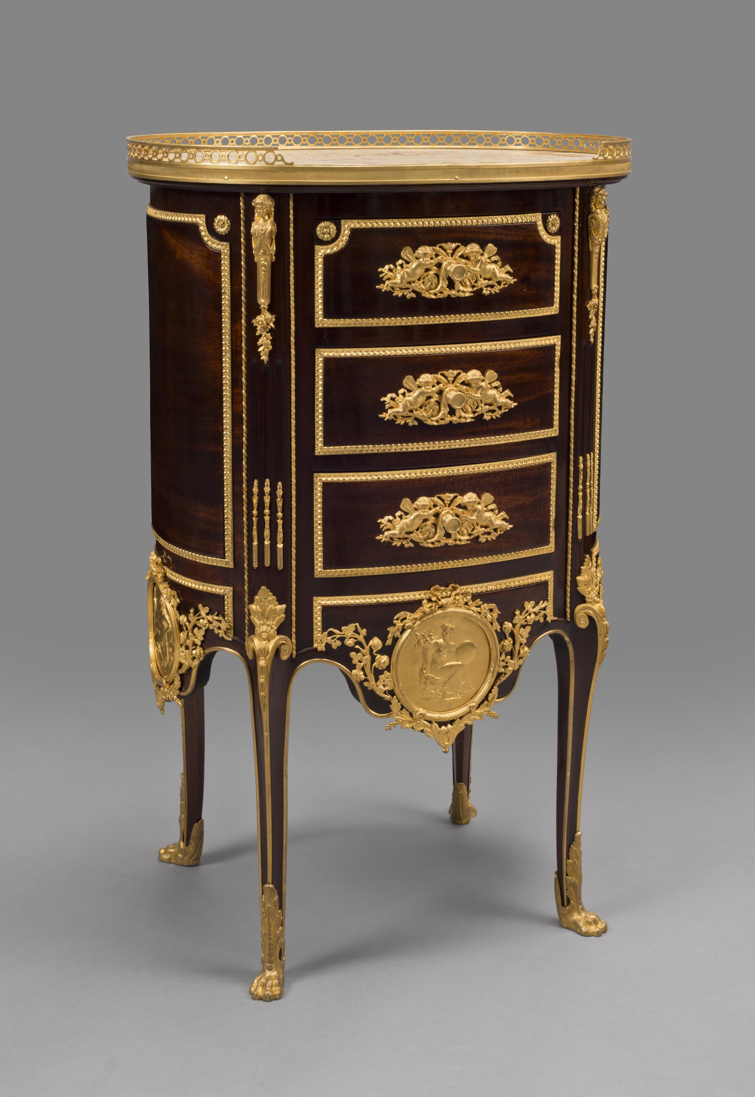 A fine transitional style gilt bronze mounted Mahogany Chiffonier Tambour. 

French, circa 1880. 

This fine chiffonier is of drum shape with a Brèche d’Alep marble top with a three-quarter gallery above three drawers. The cabinet is richly