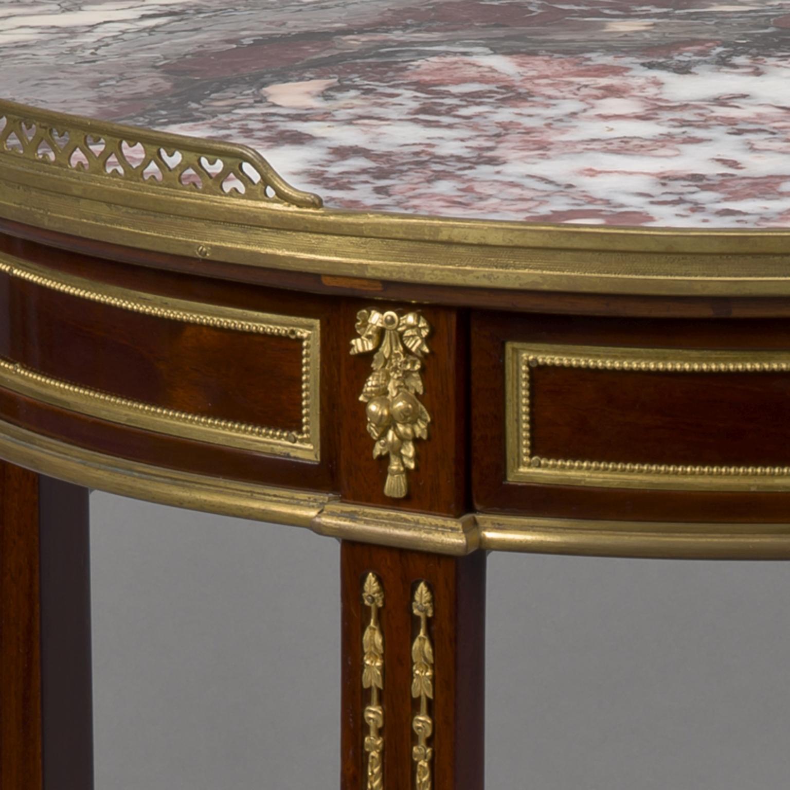 A fine transitional style gilt bronze mounted guéridon with a Breccia marble top, by Maison Millet.

The reverse of the gilt bronze stamped 'MB' for Maison Millet.

The table has a circular marble top within a pierced gallery above a frieze
